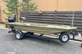 2026 Tracker Grizzly 1654 T Sportsman boat on trailer, parked outdoors.