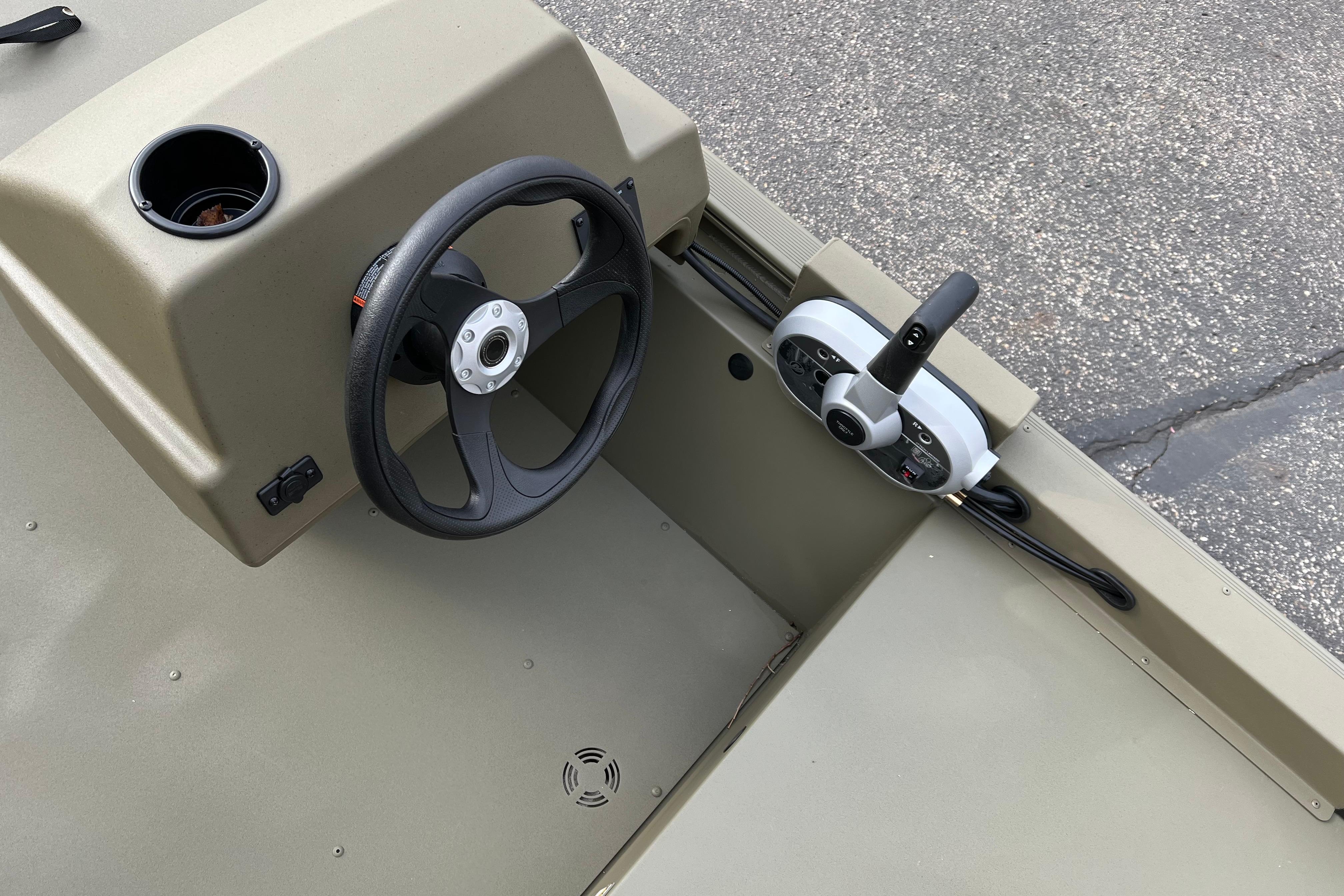 2026 Tracker Grizzly 1648 SC boat steering console with control panel and cup holder.