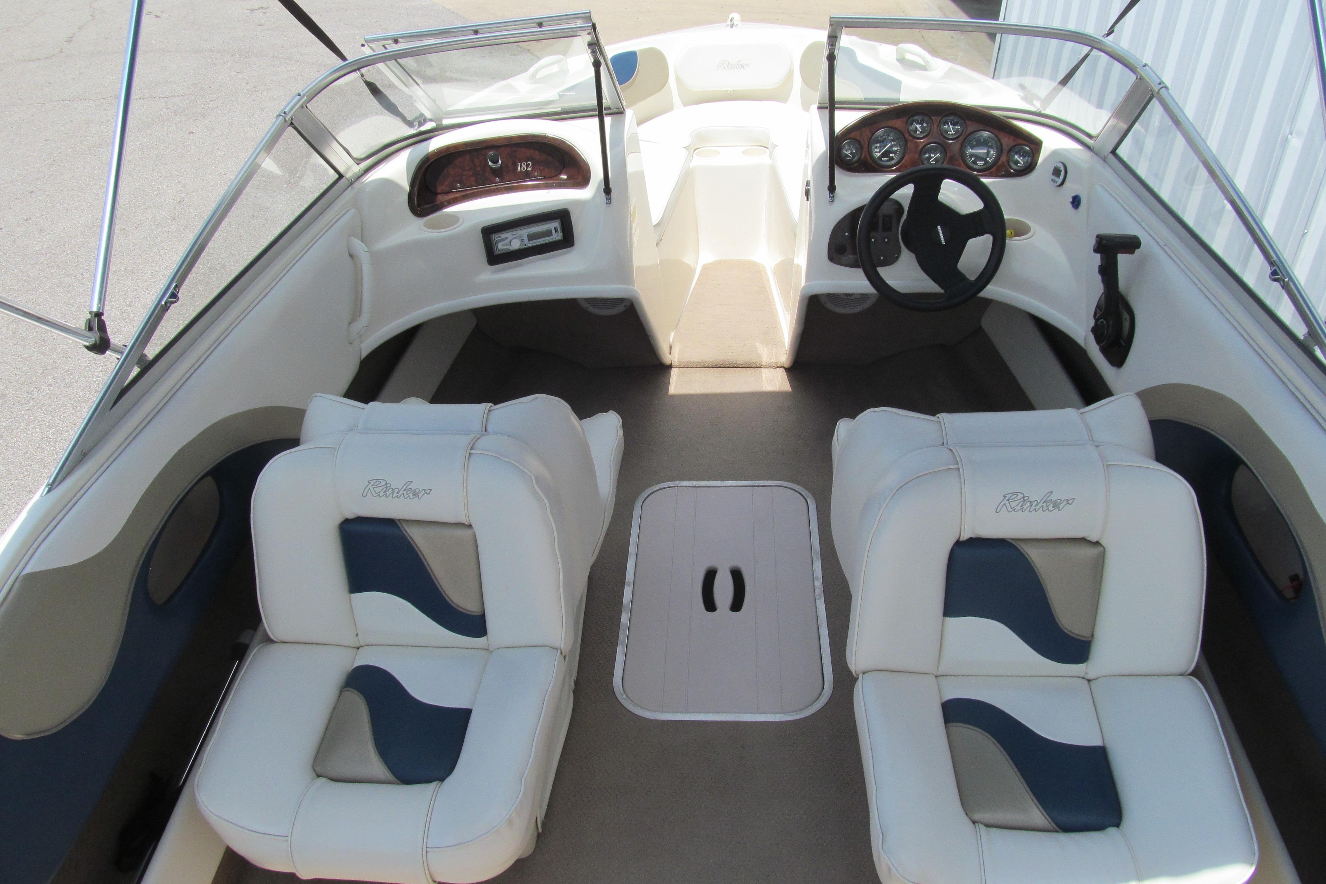 2000 Rinker boat interior with dual white seats and dashboard controls.