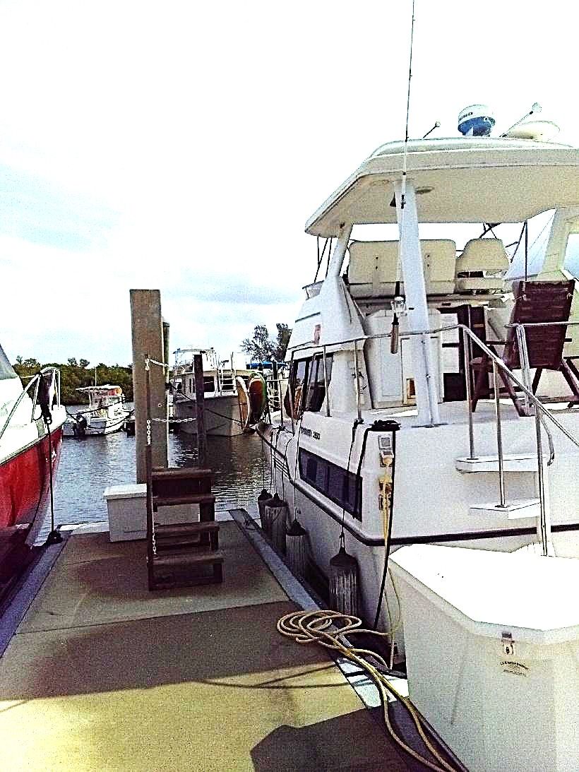 A 1995 Carver 35 boat docked. It features an elevated helm and is surrounded by other boats.