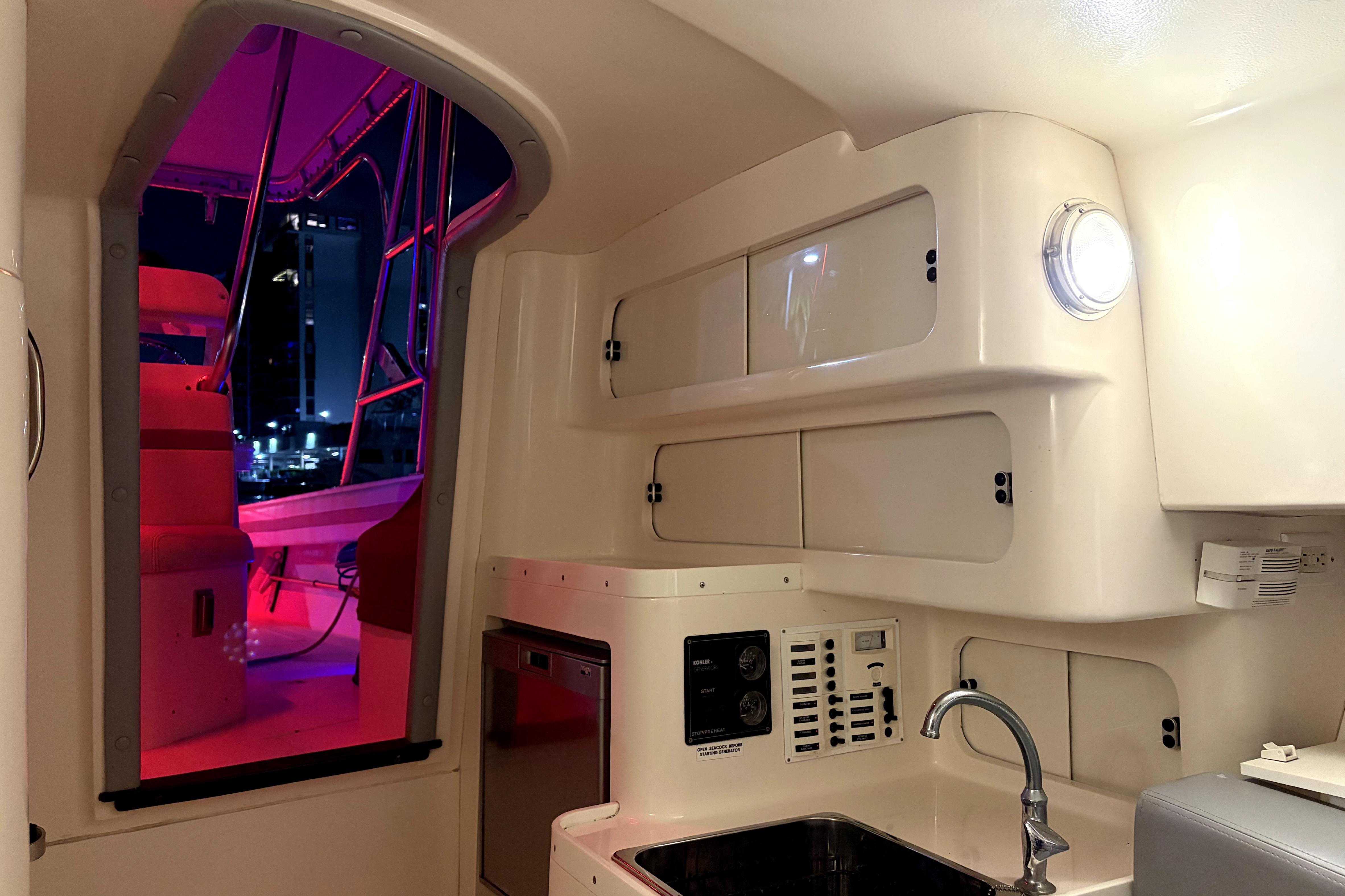 Interior of a 1998 Intrepid 339 Walkaround boat with modern amenities and vibrant lighting.