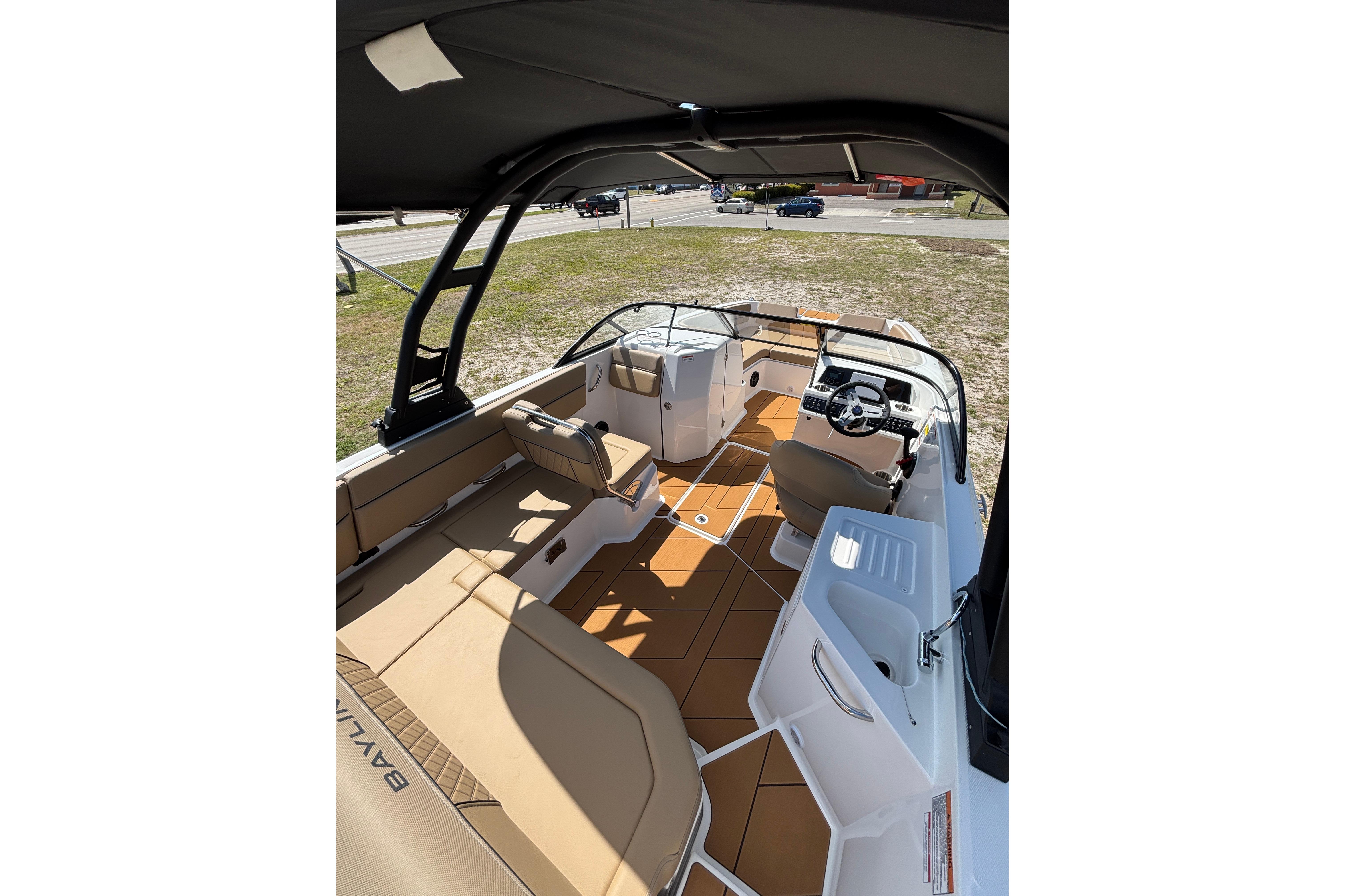 2026 Bayliner D22 boat interior with tan seating, steering console, and open deck layout.