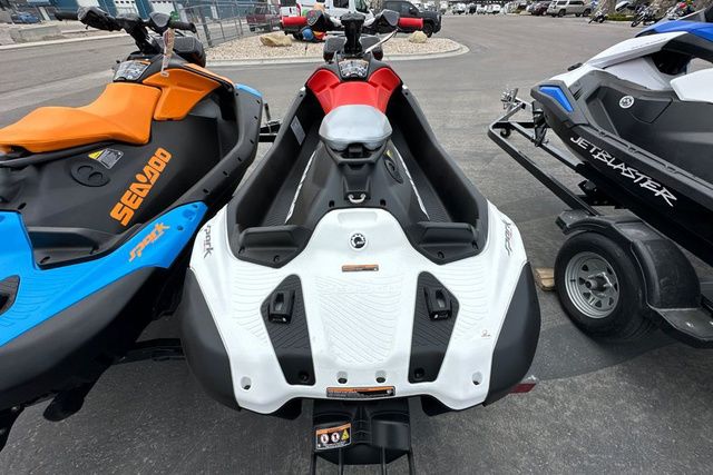 Three jet skis are parked on a lot. The Sea-Doo SPARK TRIXX is in the center.