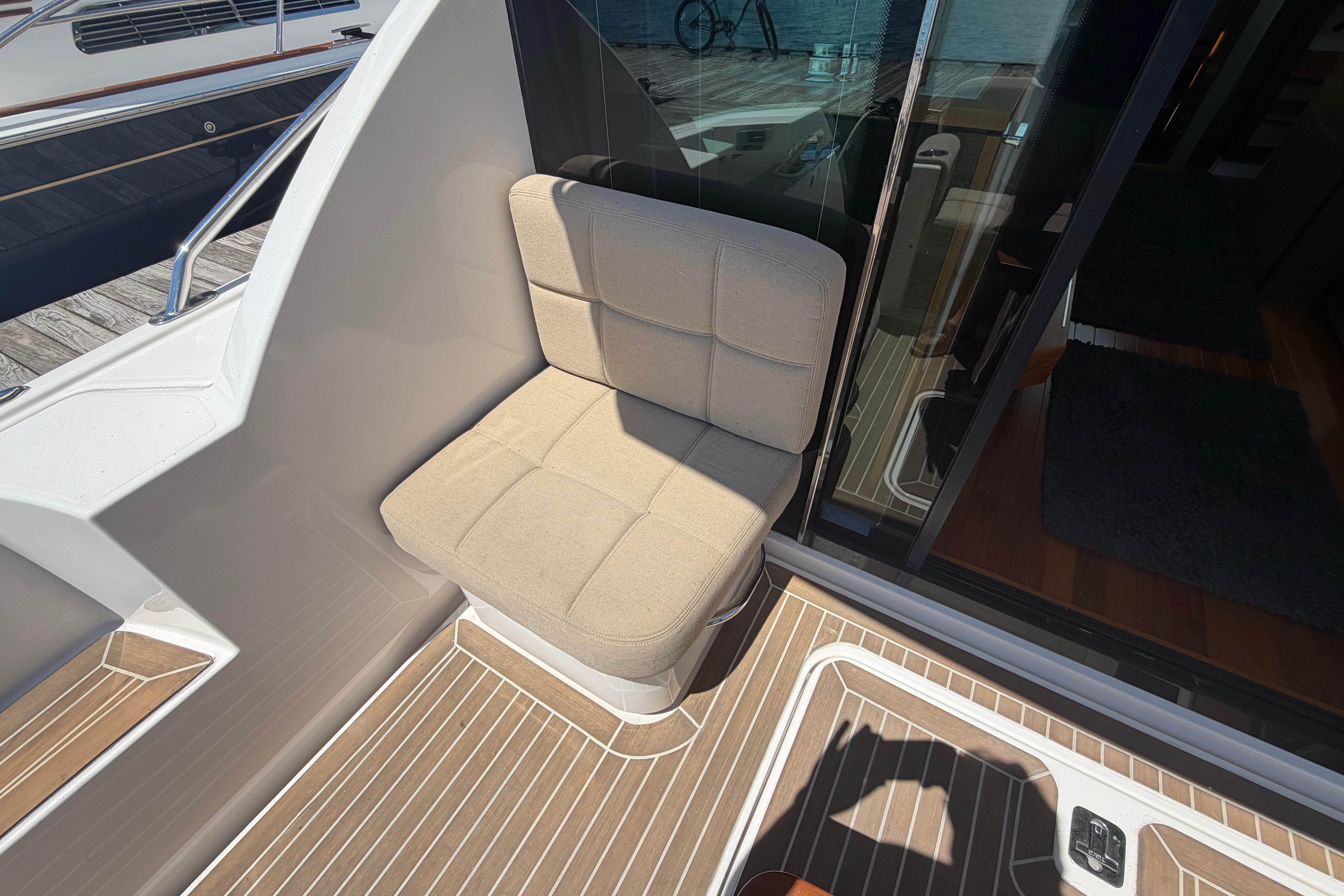 2016 Tiara Yachts C39 Coupe seating area with beige cushion and teak flooring.