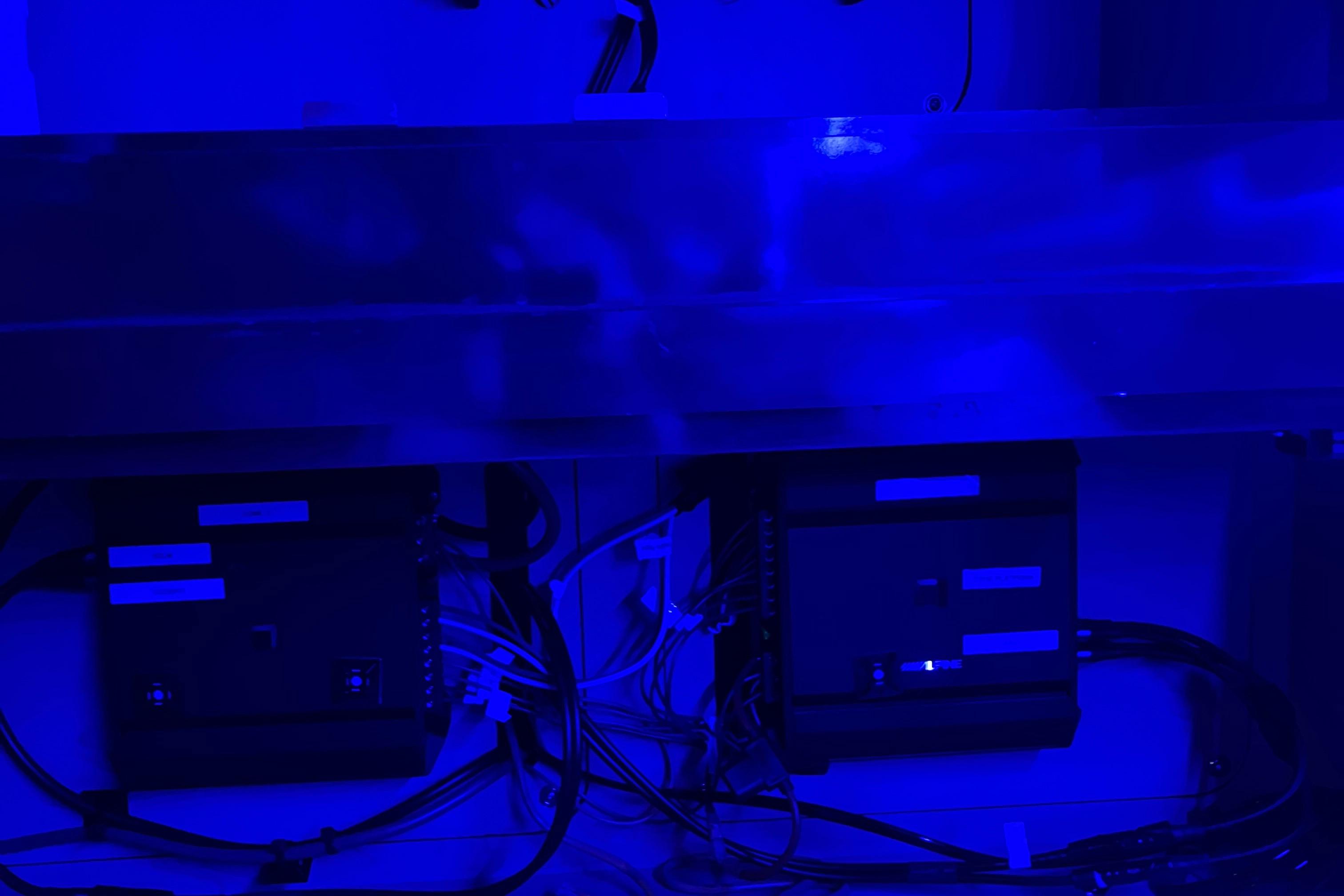 Electrical components in blue-lit compartment of 2008 Sea Ray 350 Sundancer boat.