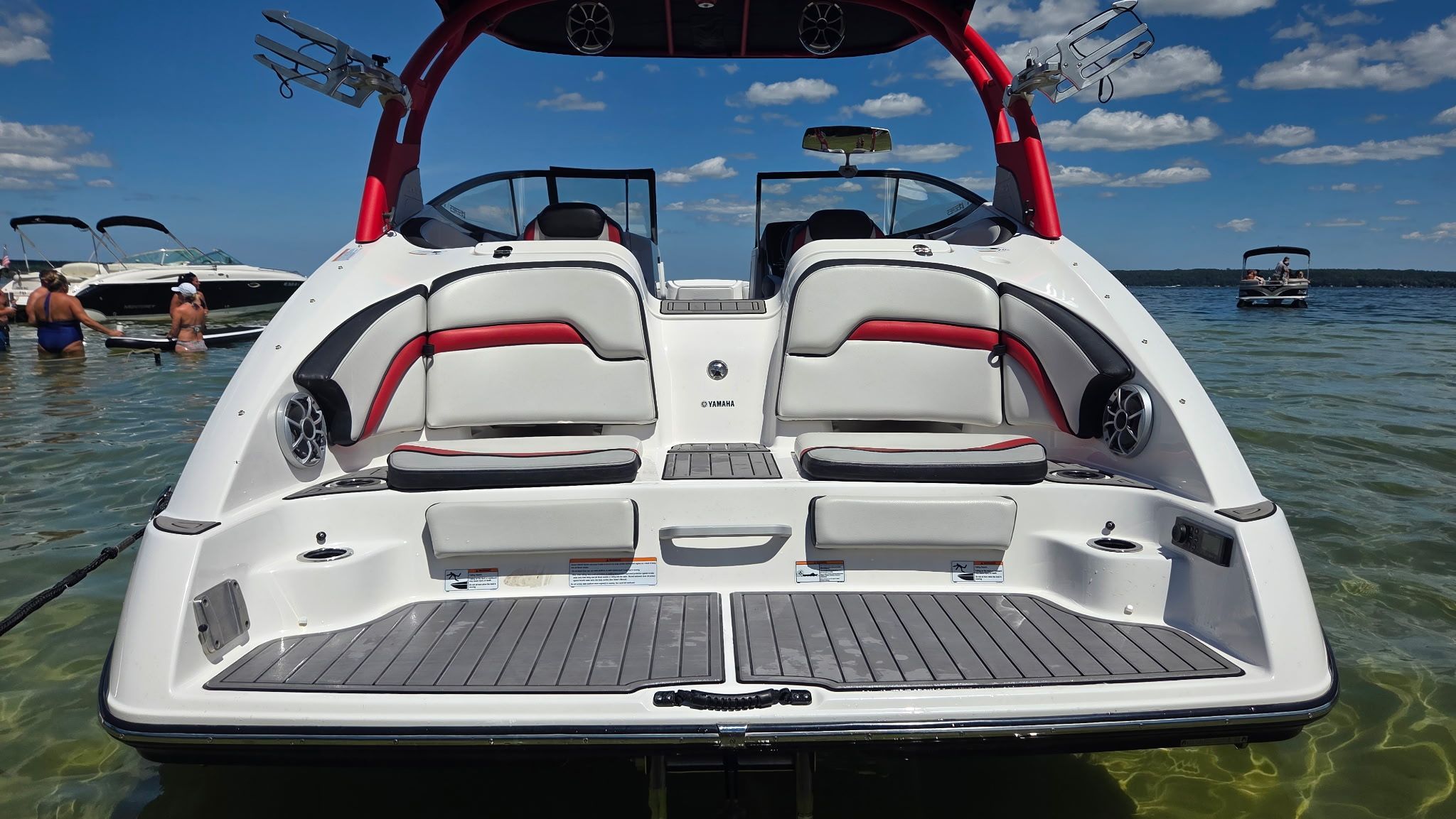 The image shows a 2018 Yamaha 242X E-Series boat on the water, featuring a red wakeboard tower.