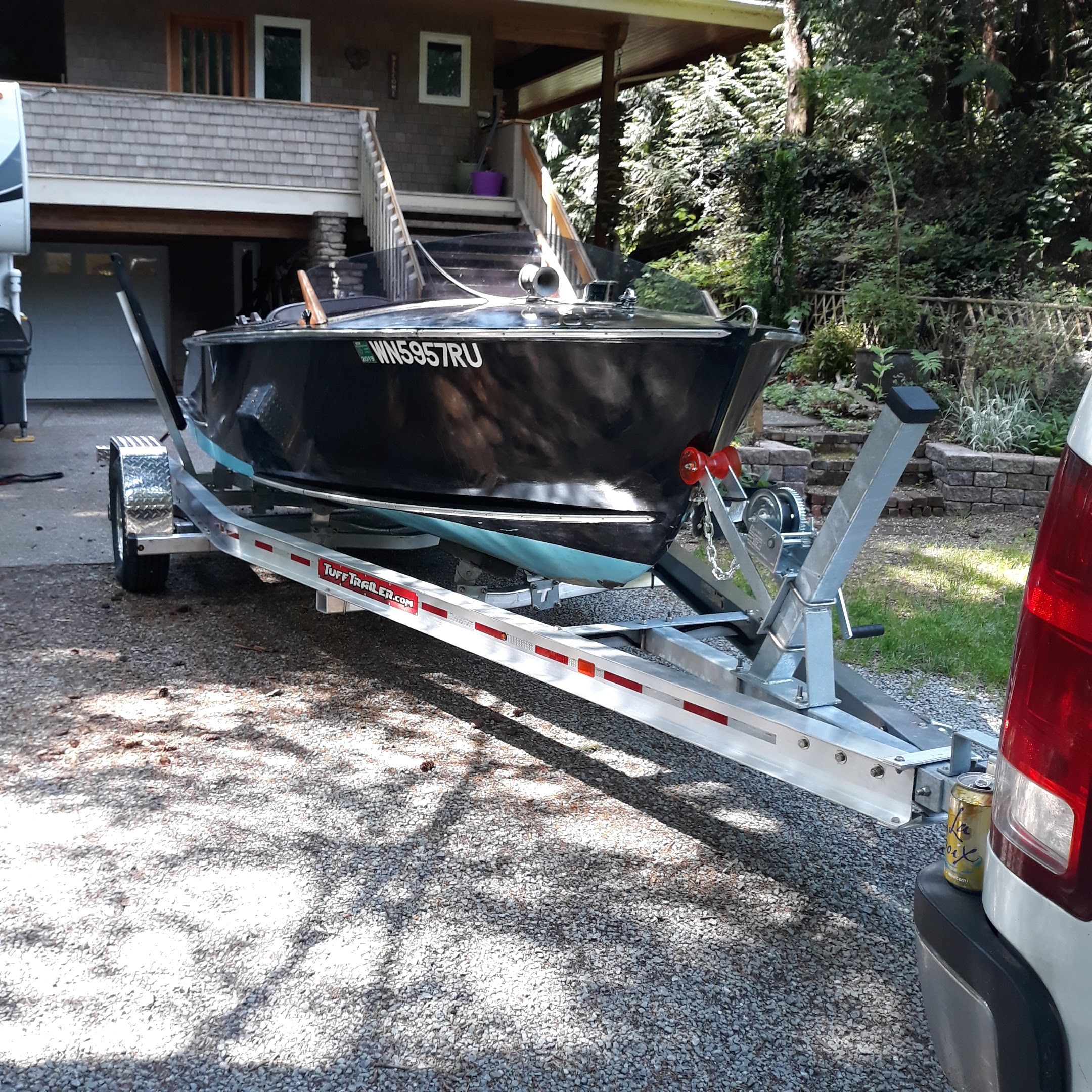 1948 Higgins 17.5 ft Runabout on trailer in front of house.