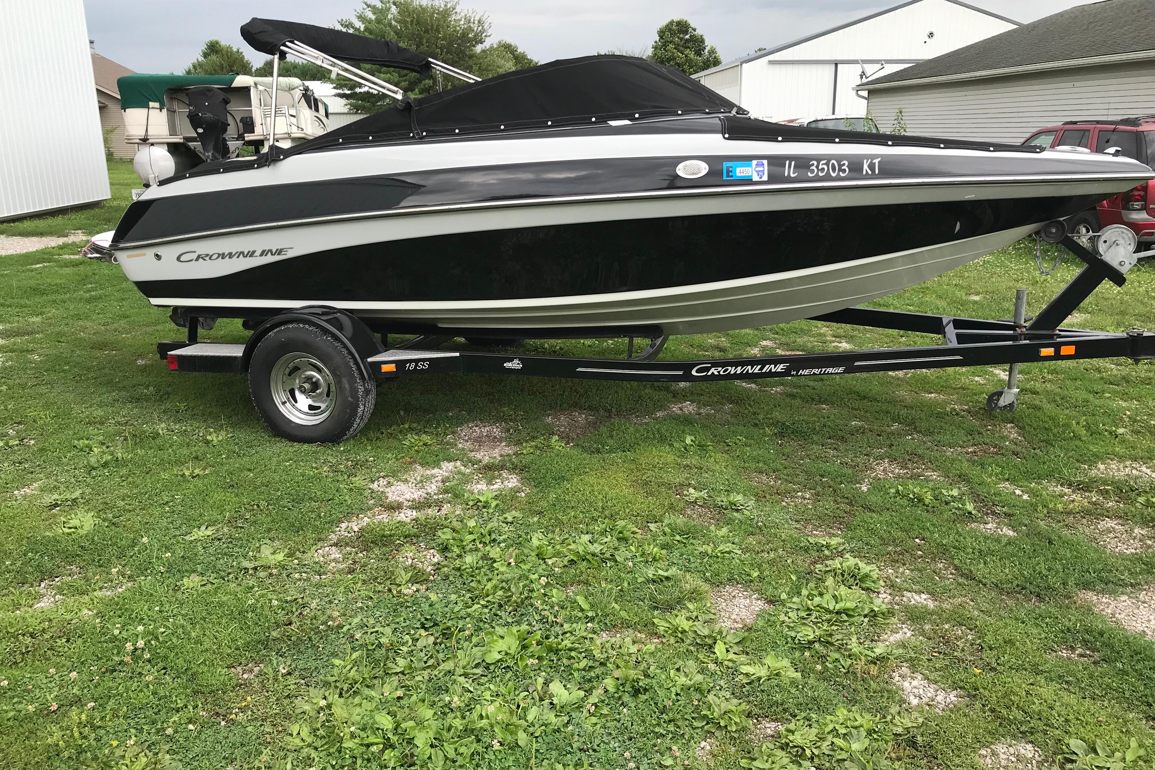 2015 Crownline 18 SS boat on trailer, parked on grass.