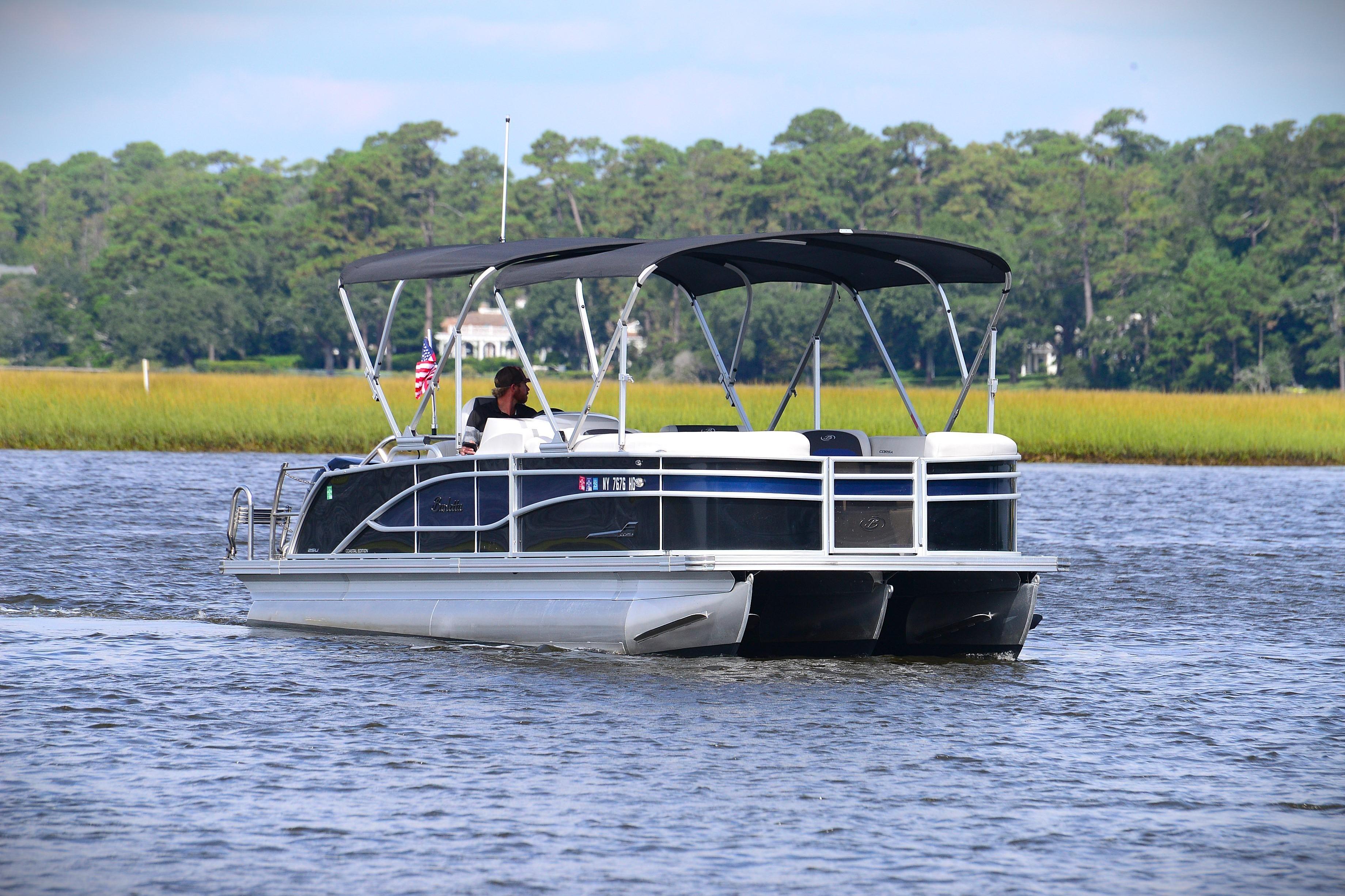 2022 Barletta Corsa 25U pontoon boat cruising on a scenic lake.