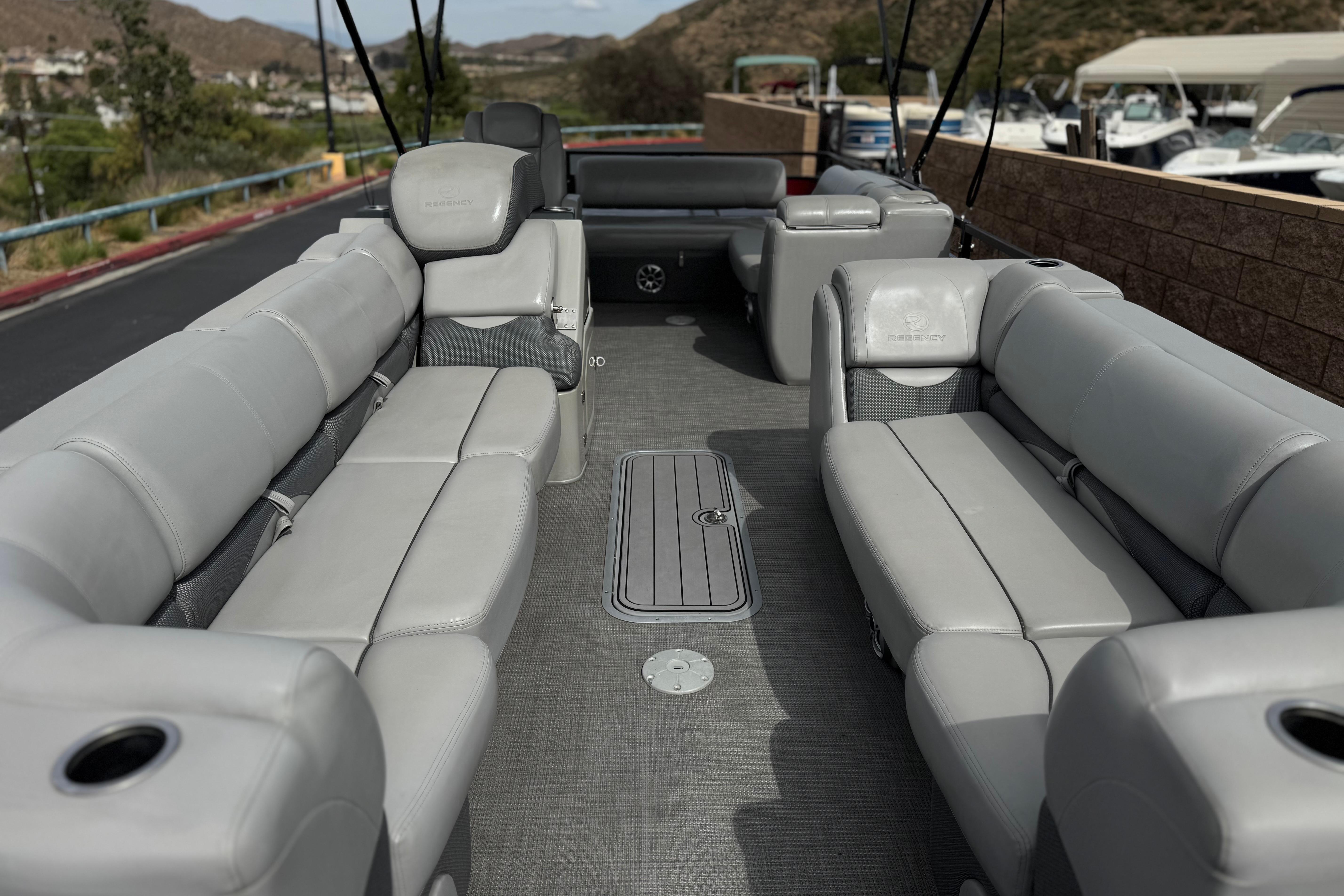 2022 Regency 250 DL3 pontoon boat interior with gray seating and spacious layout.