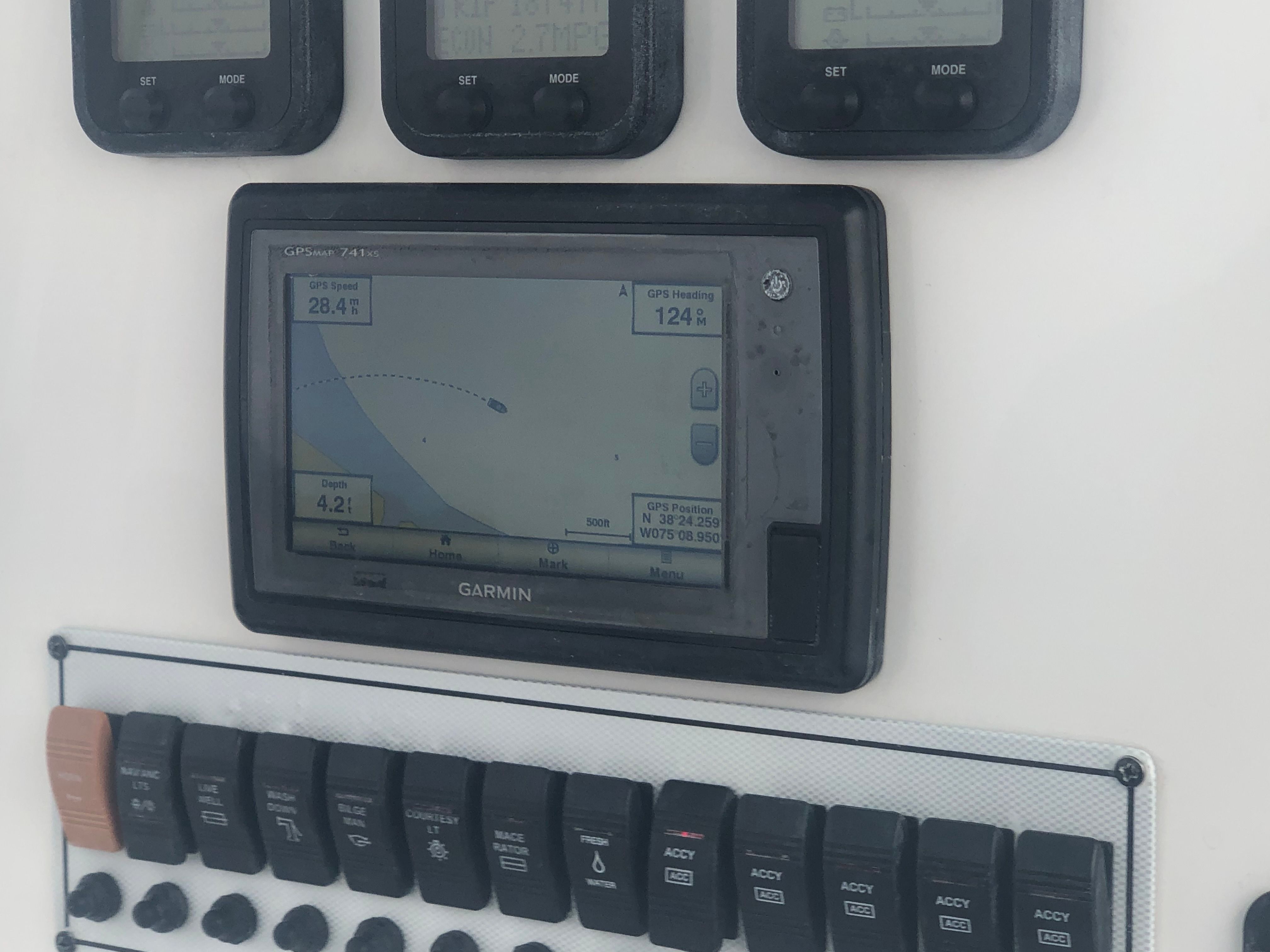 The image shows a Garmin GPS device and switches on a boat.
