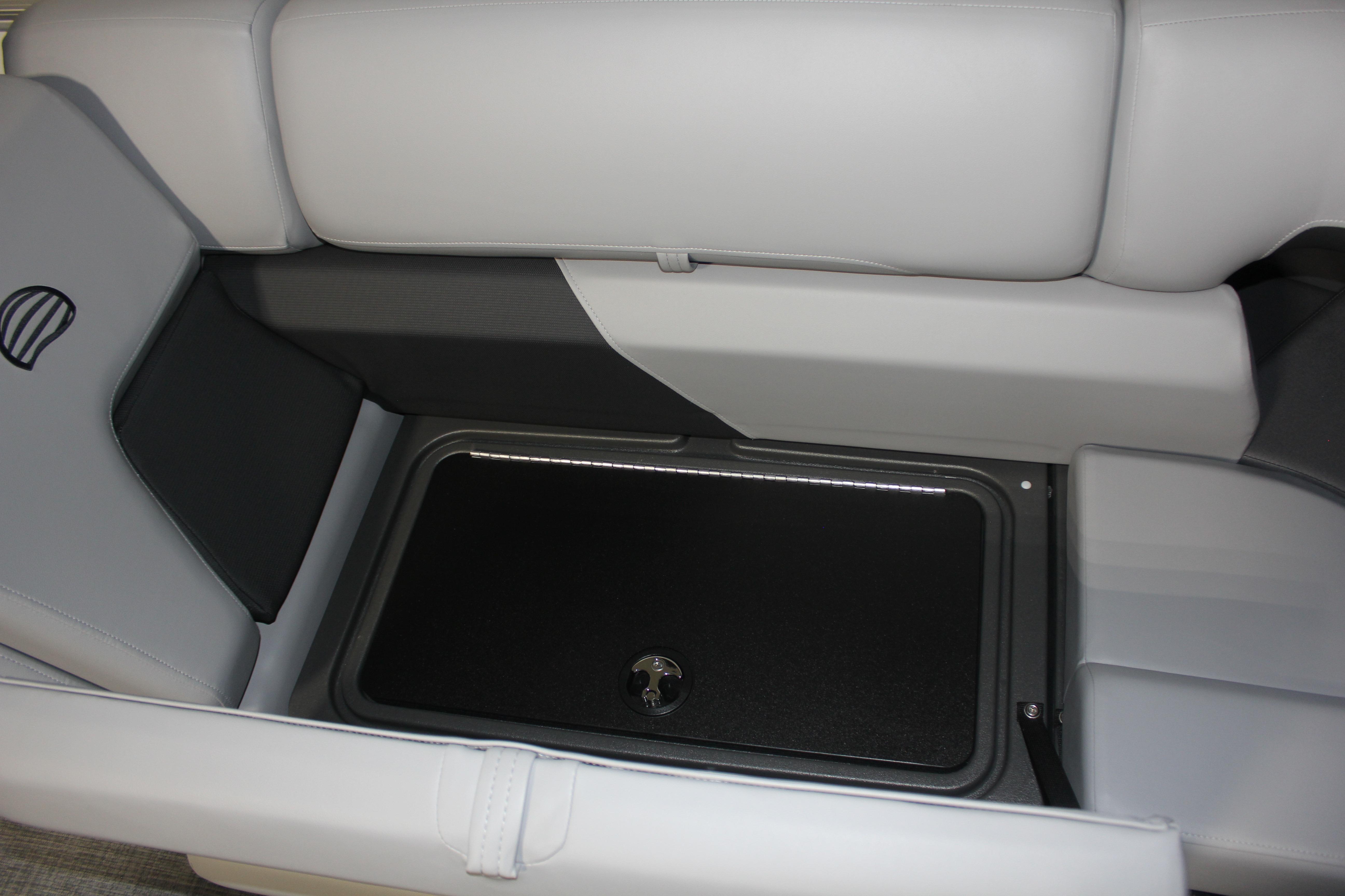 2026 Sun Tracker Party Barge 22 DLX interior storage compartment with cushioned seating.