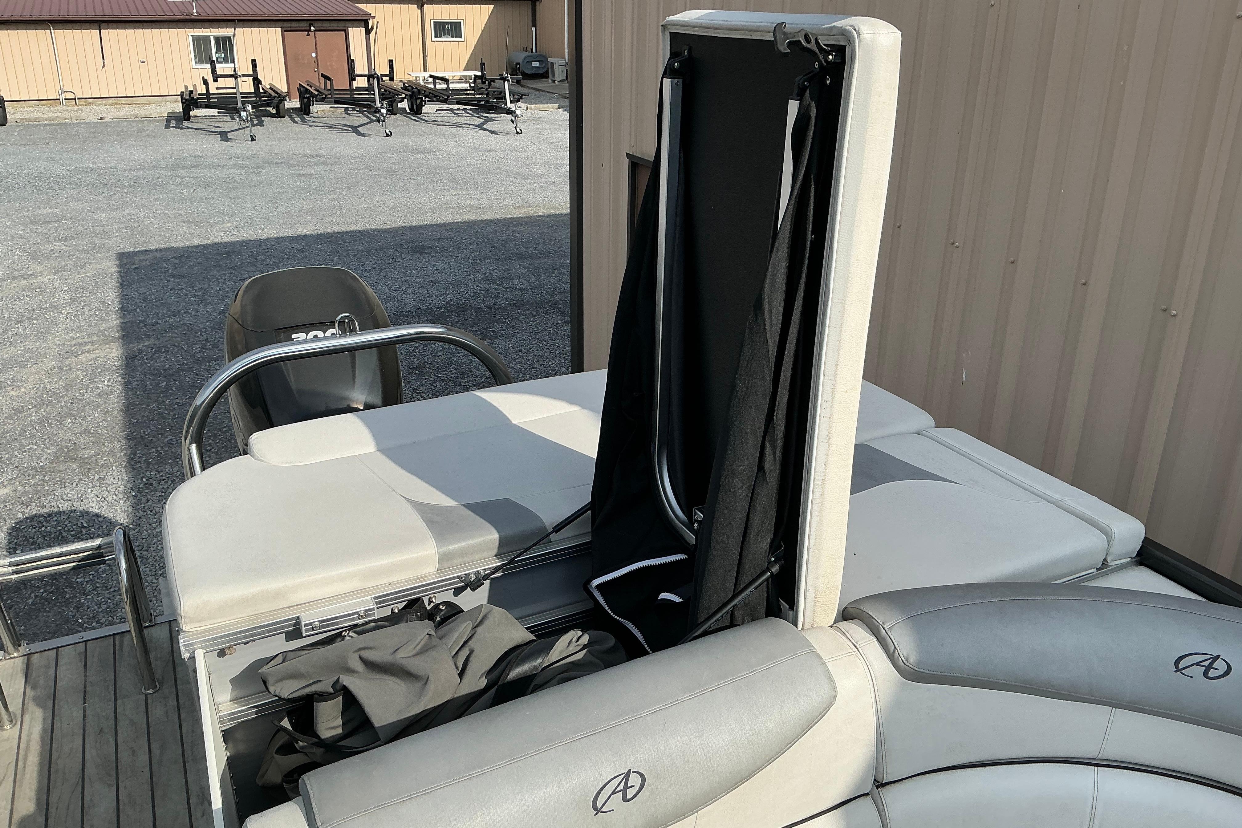 2014 Avalon 25 ft. Paradise Elite pontoon boat with seating and storage, parked outdoors.
