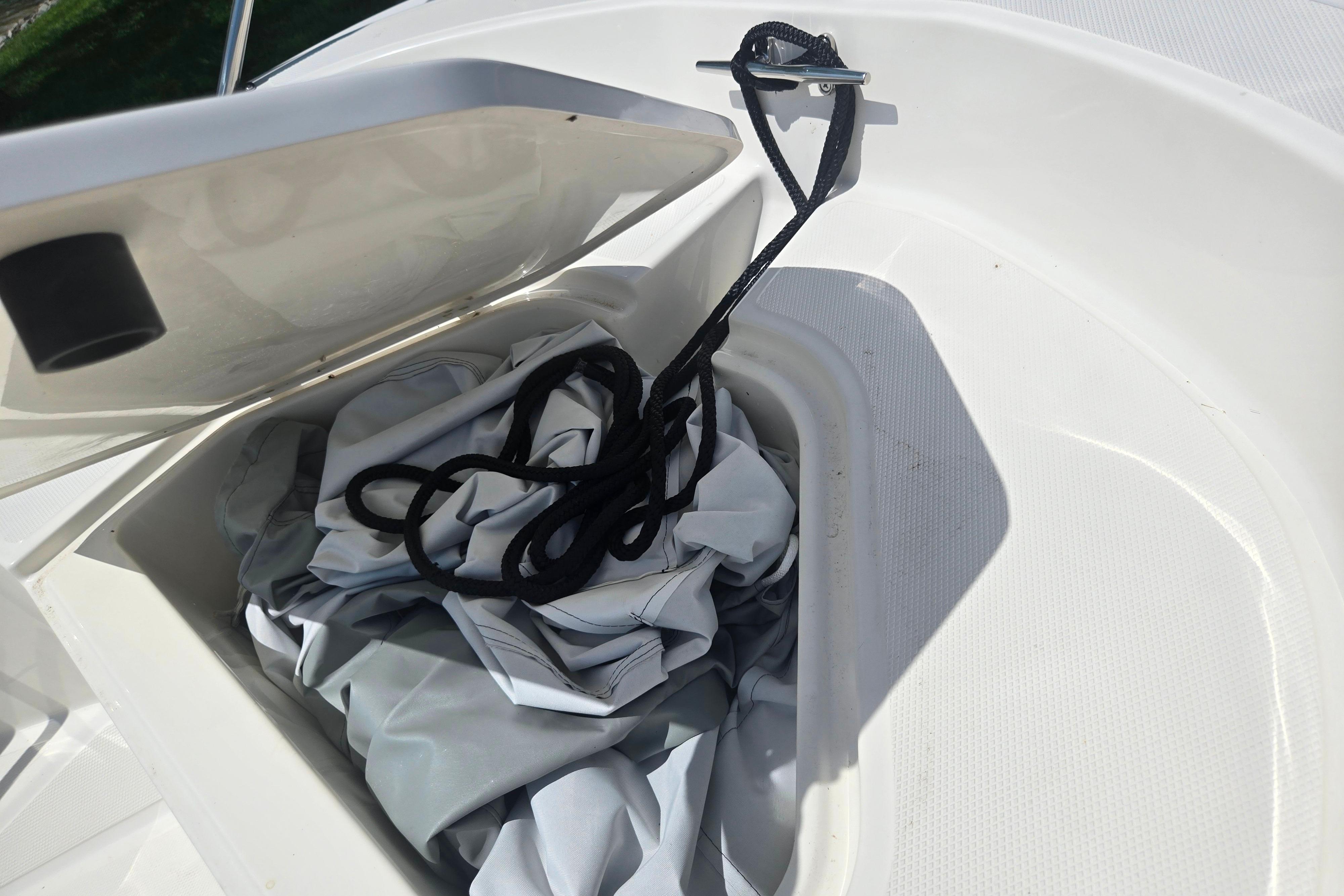 Open storage compartment on 2025 Boston Whaler 130 Super Sport boat with rope inside.