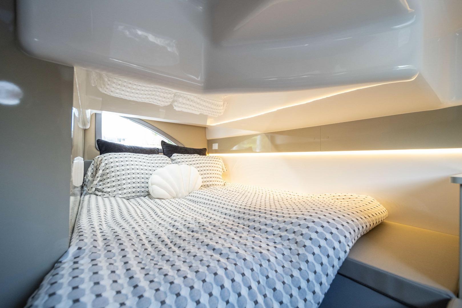 Luxurious interior of 2026 Hanover 387 yacht with cozy bed and modern lighting.