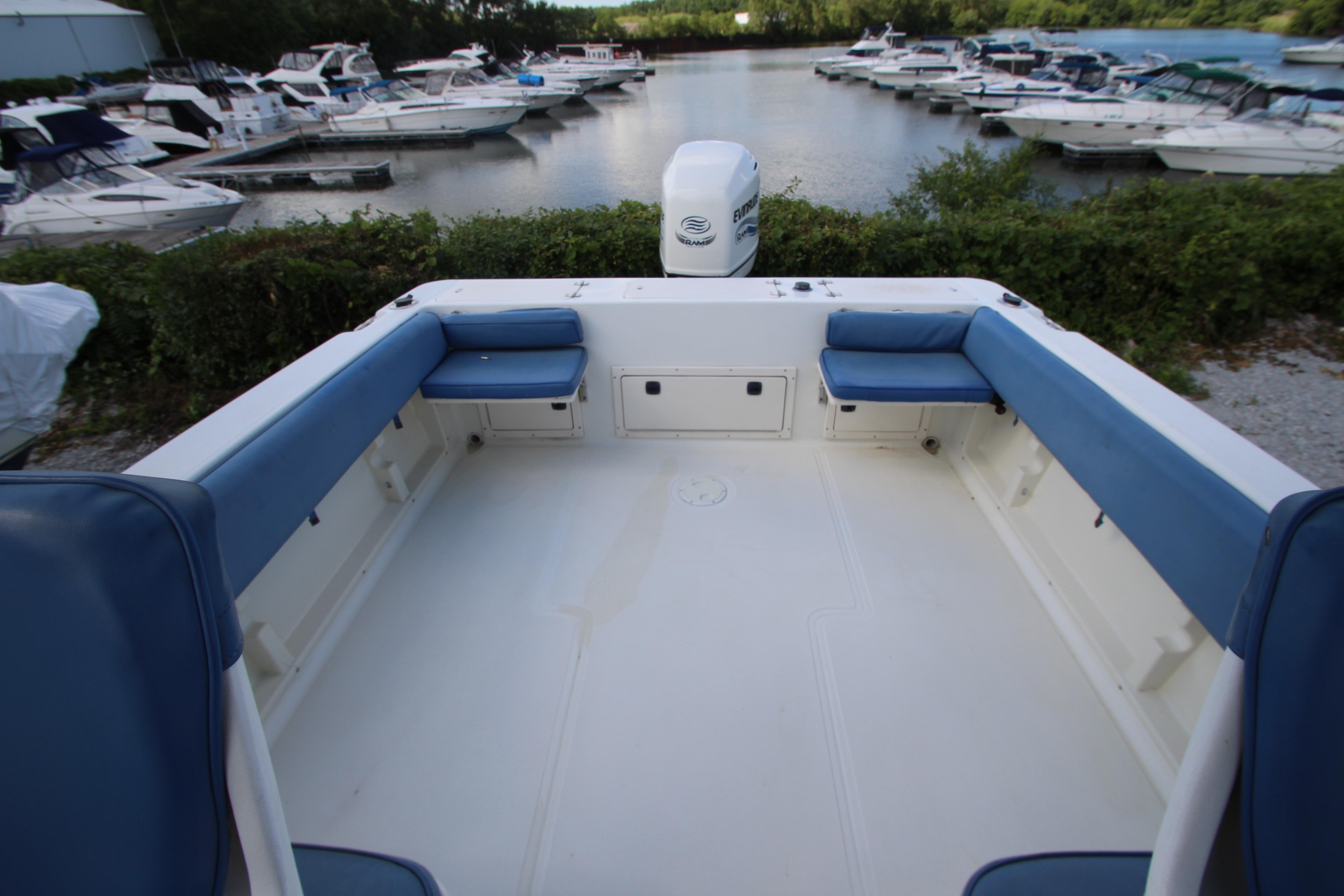 2002 Hydra-Sports 230 WA boat interior with blue seating, docked at marina.