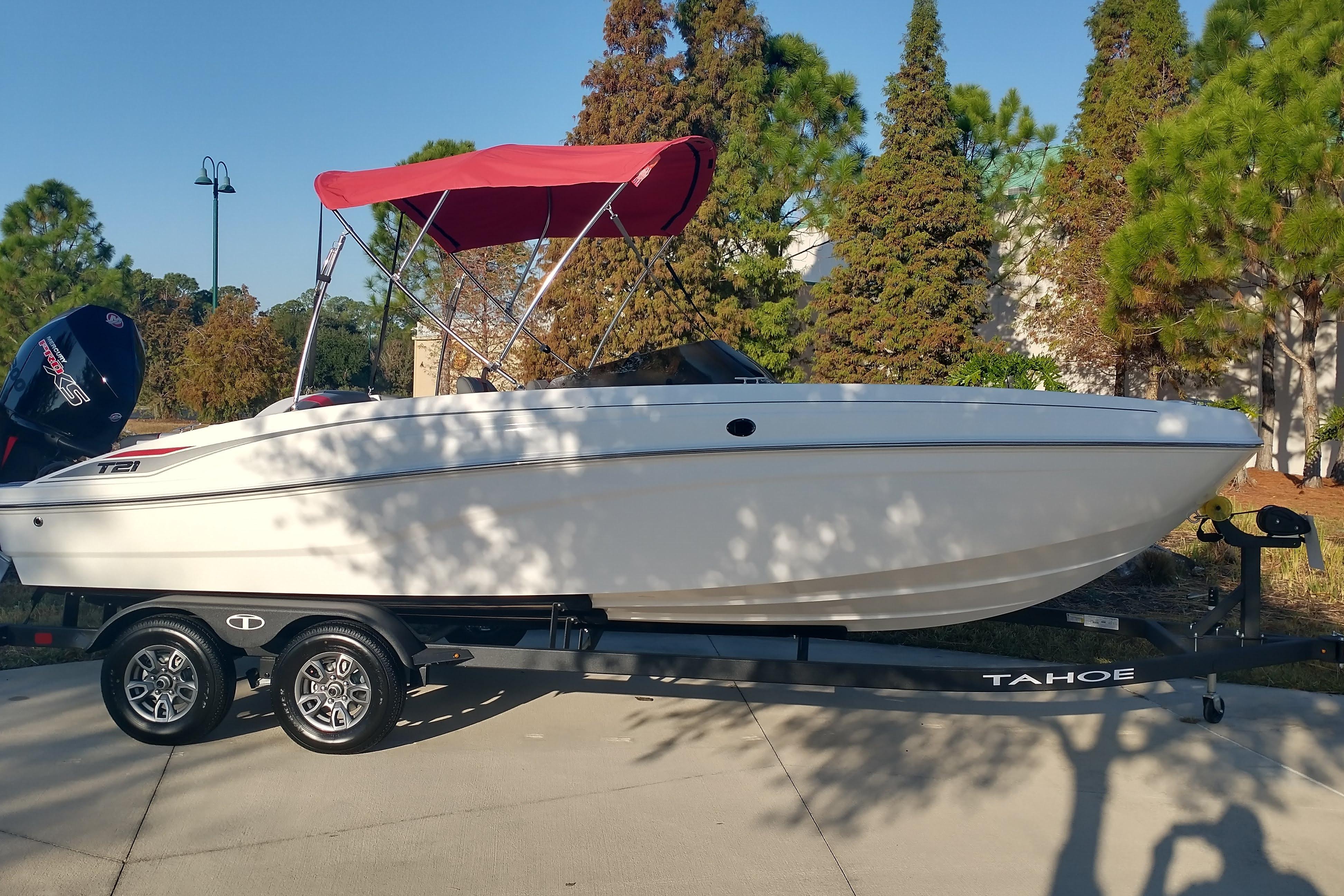 2026 Tahoe T21 boat with red canopy on trailer, parked outdoors.