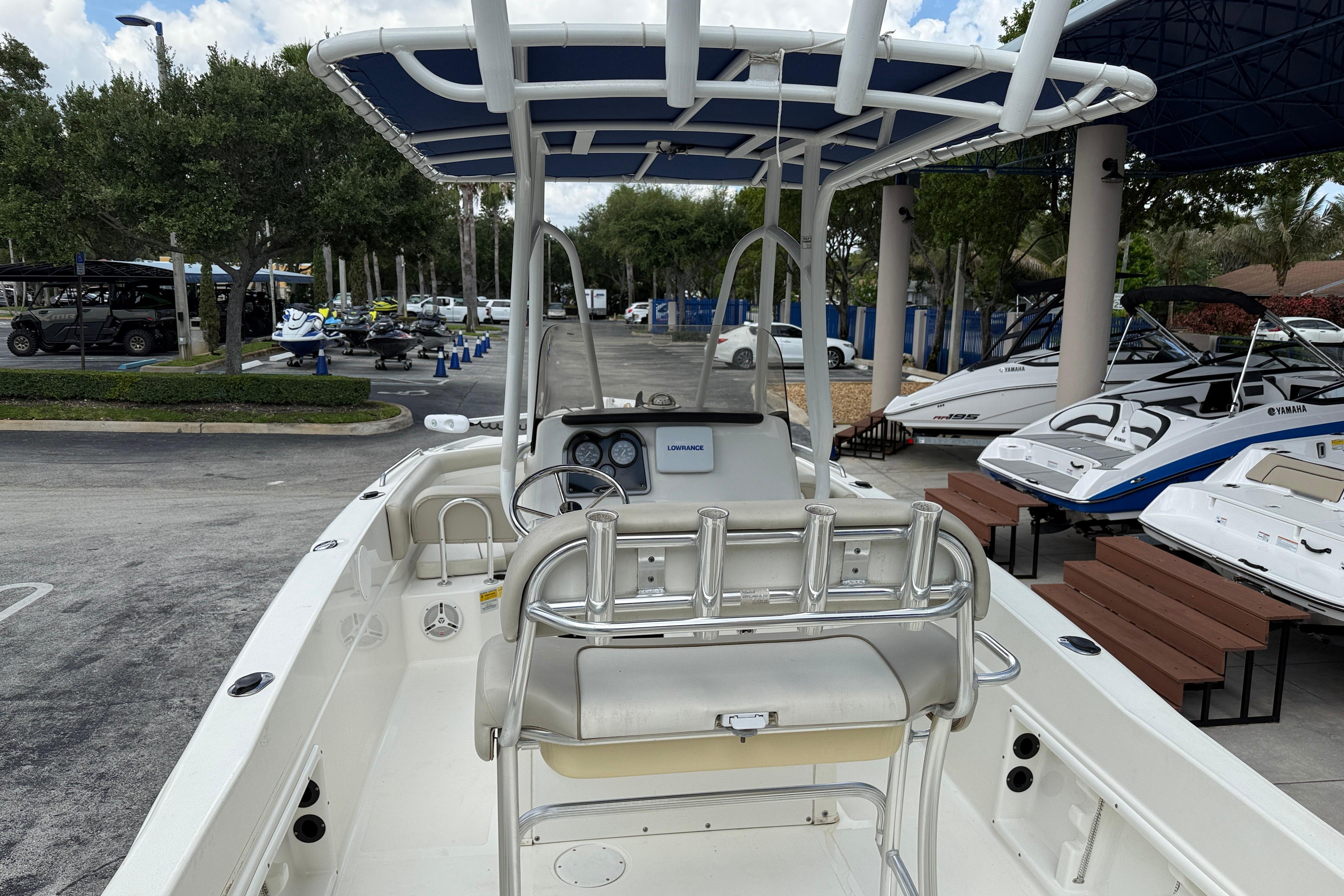 2015 NauticStar 231 Coastal boat with T-top, parked in a marina with other boats.