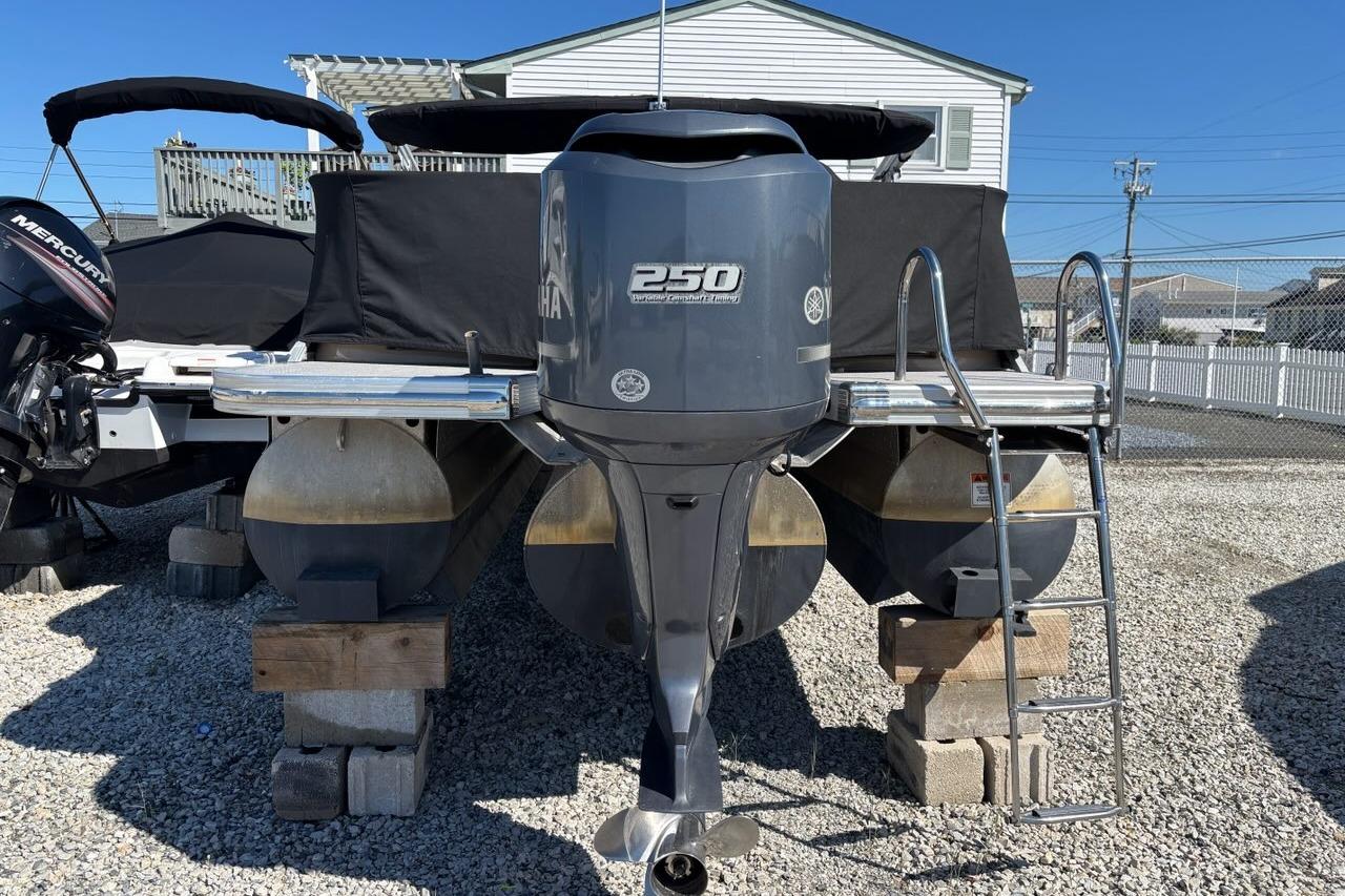 2014 Bennington 2575 RCW pontoon boat with Yamaha 250 engine on gravel lot.