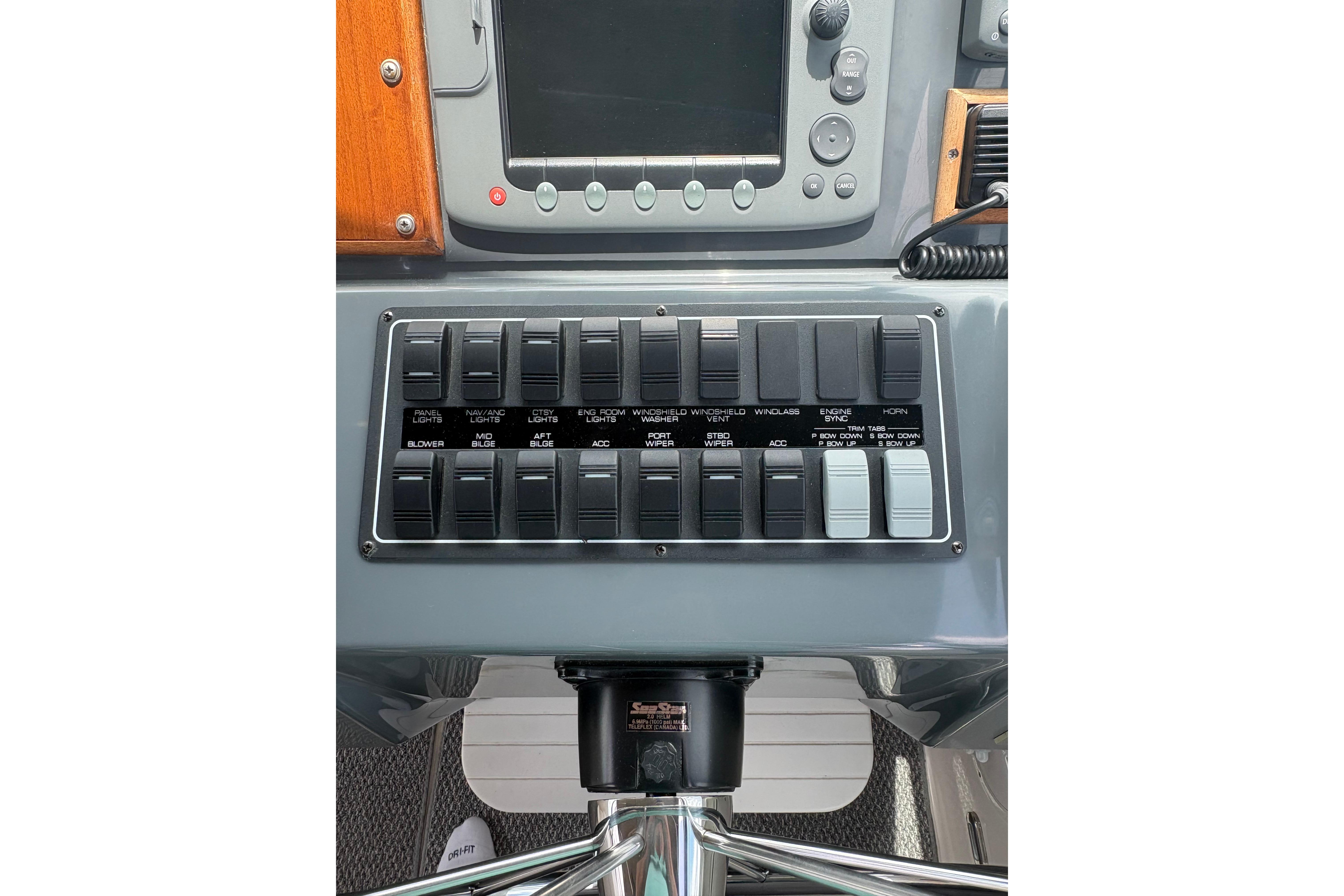 Control panel of a 1999 Tiara Yachts 3100 Open, featuring various switches and a display.