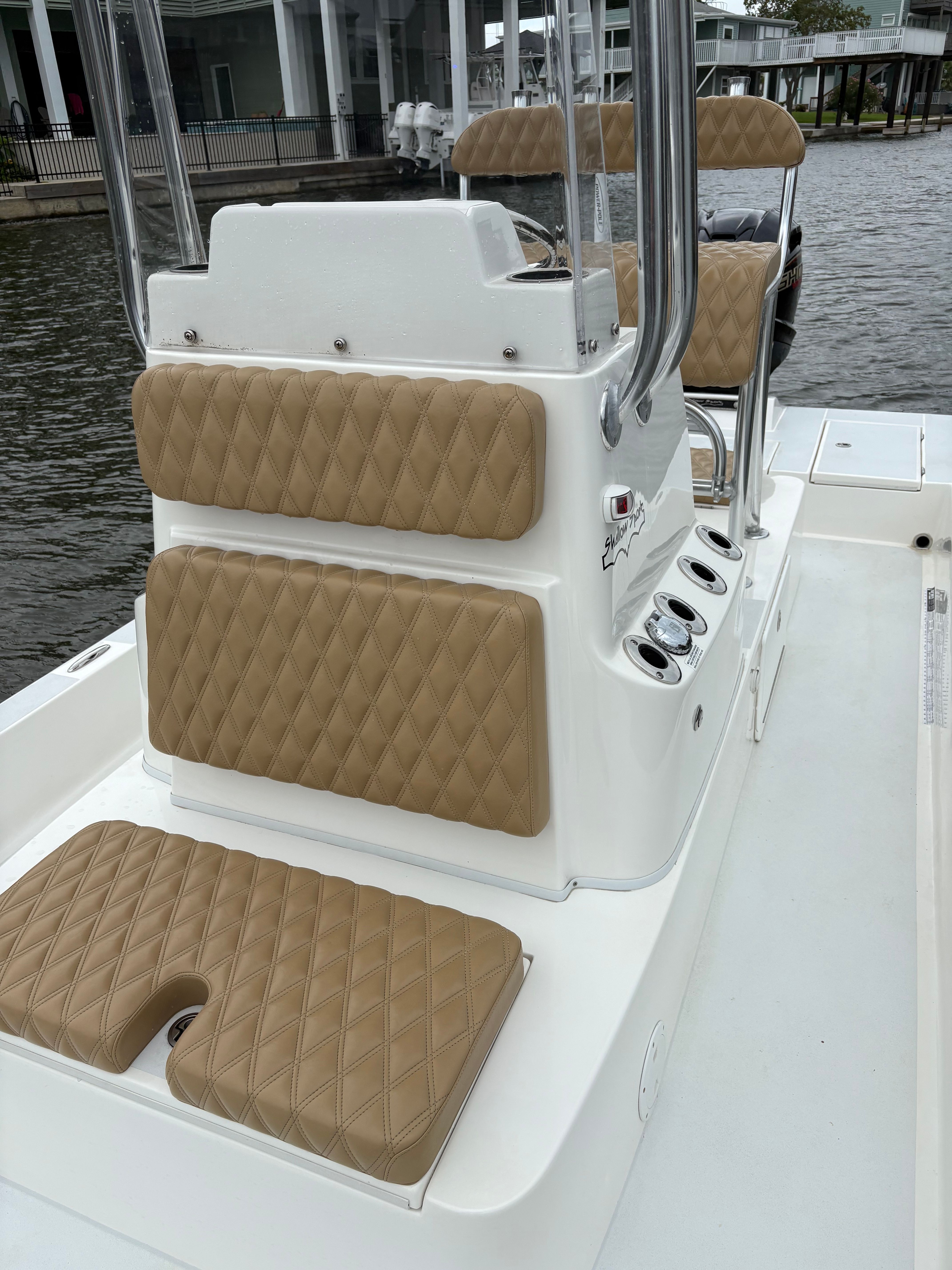 The image shows the cockpit of a Shallow Sport 24 Sport boat with cushioned seats.