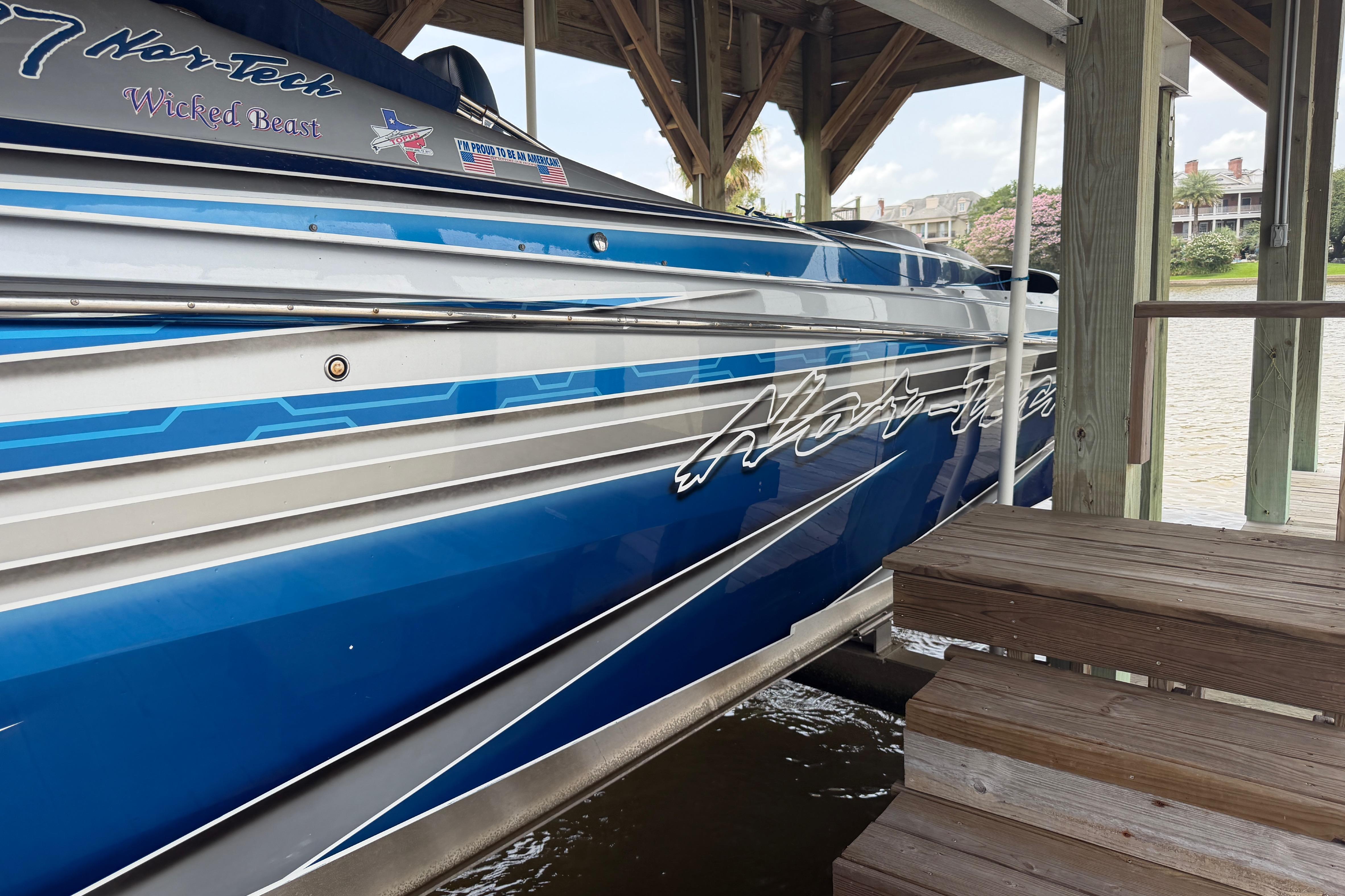 2013 Nor-Tech 477 SPX Vee Bottom boat docked, showcasing sleek blue and silver design.