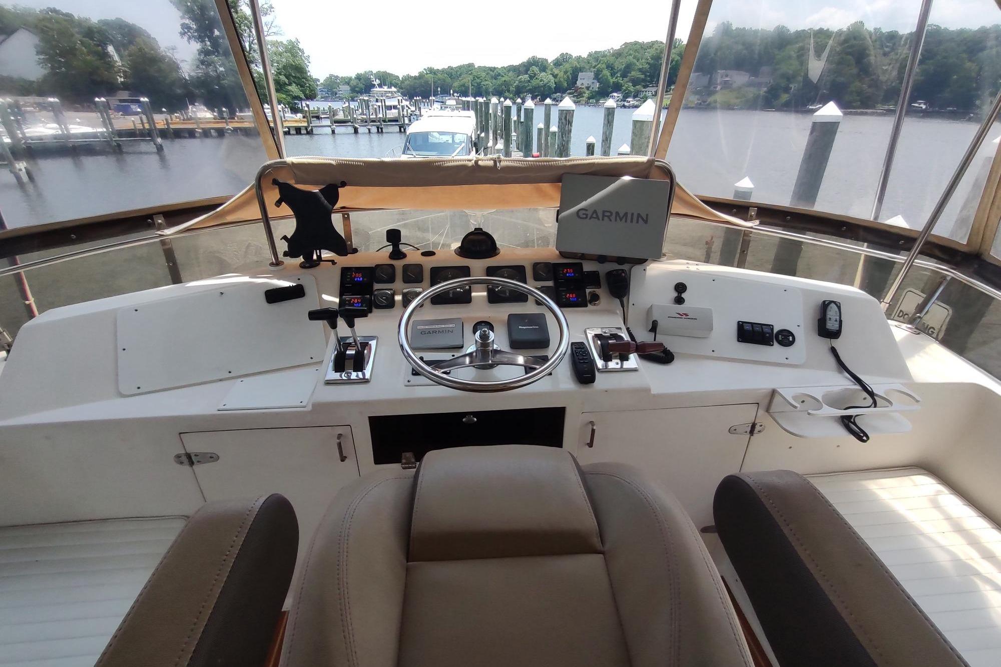 Helm of 1989 Hyatt Double Cabin Motoryacht with Garmin navigation, docked at marina.