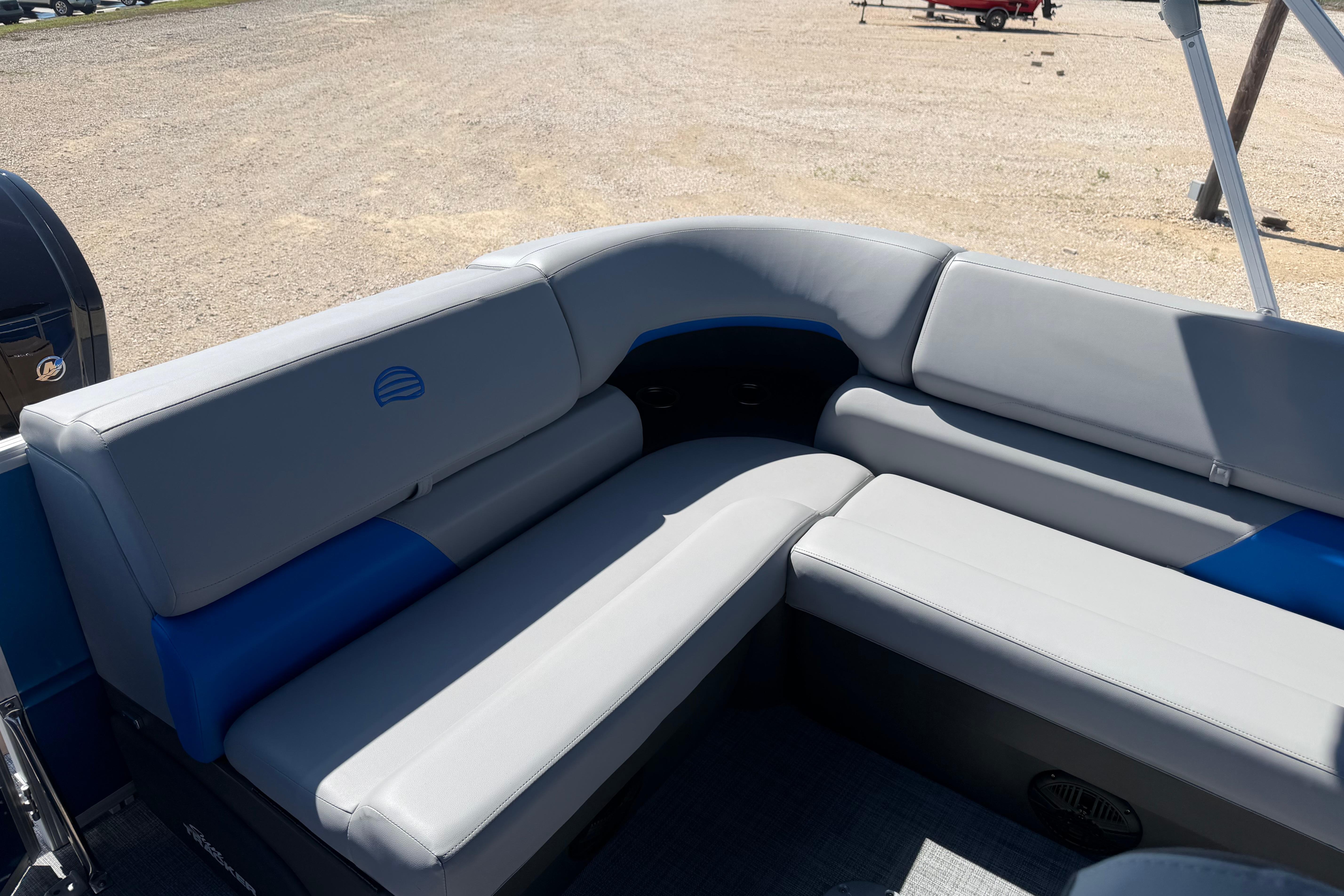 2026 Sun Tracker Party Barge 20 DLX with gray and blue seating on a sunny day.