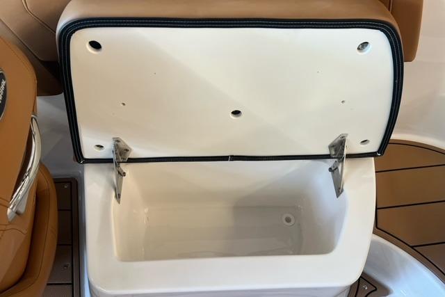 Open storage compartment in 2025 Chaparral 247 SSX boat, featuring tan and white interior.