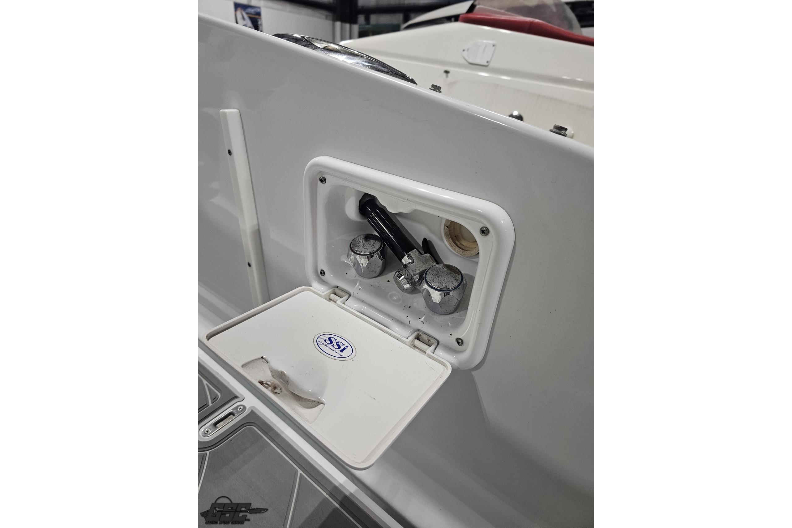 2008 Baja 335 Performance boat compartment with open hatch and controls.
