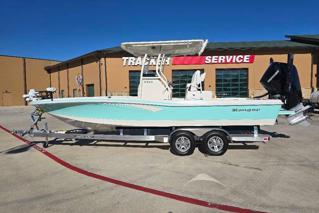 2025 Ranger 2510 Bay boat on trailer outside service center, side view.
