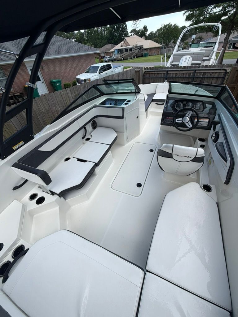 A Sea Ray SPX 210 Outboard boat with white seating and a modern cockpit.