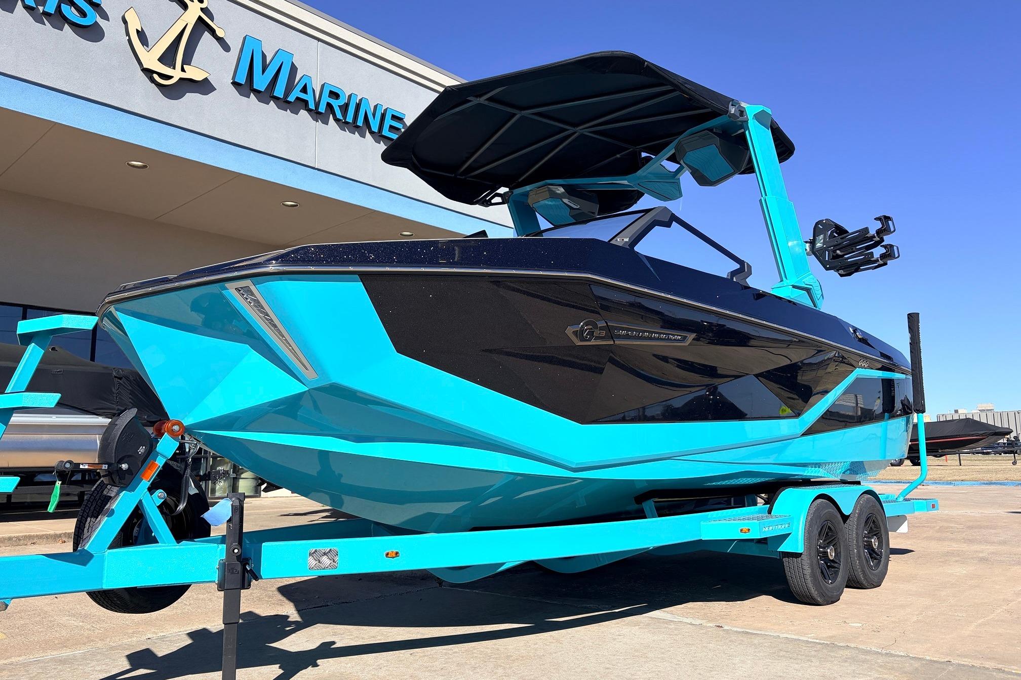 2026 Nautique Super Air Nautique G23 boat in vibrant blue on trailer outside dealership.