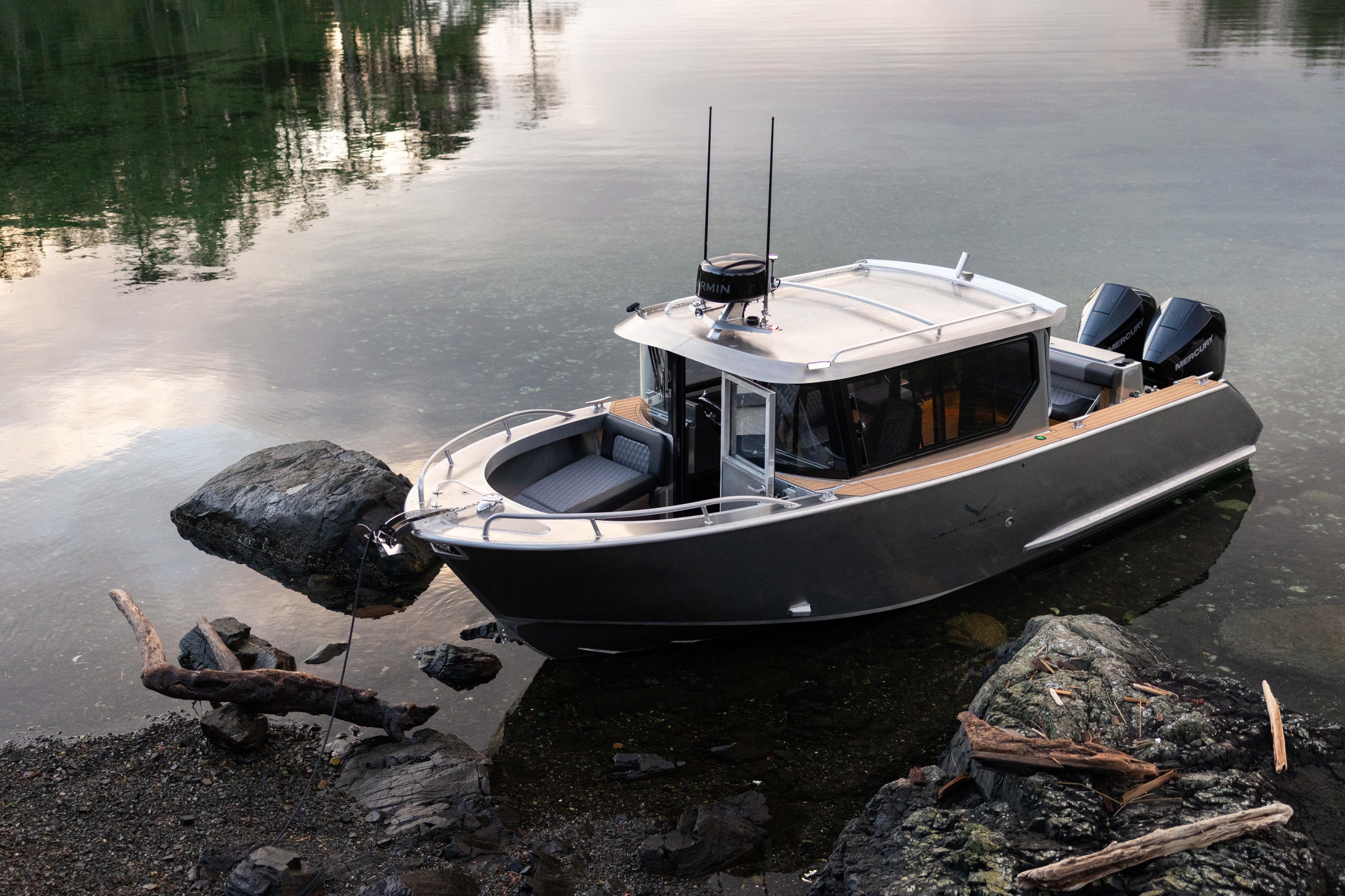 2026 Jasper Marine Defender 22 boat docked on calm water near rocky shore.