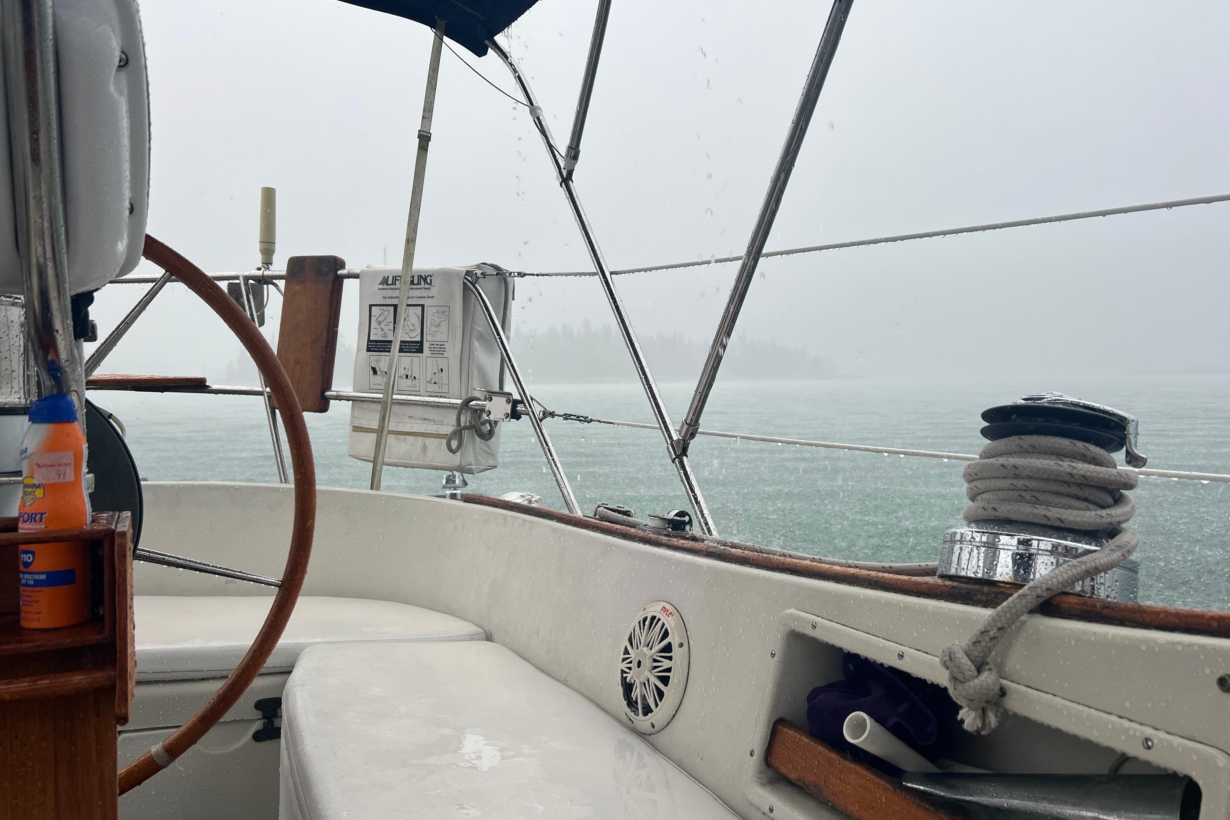 Cockpit view of a 1982 Pacific Seacraft 37 sailboat in rainy weather.