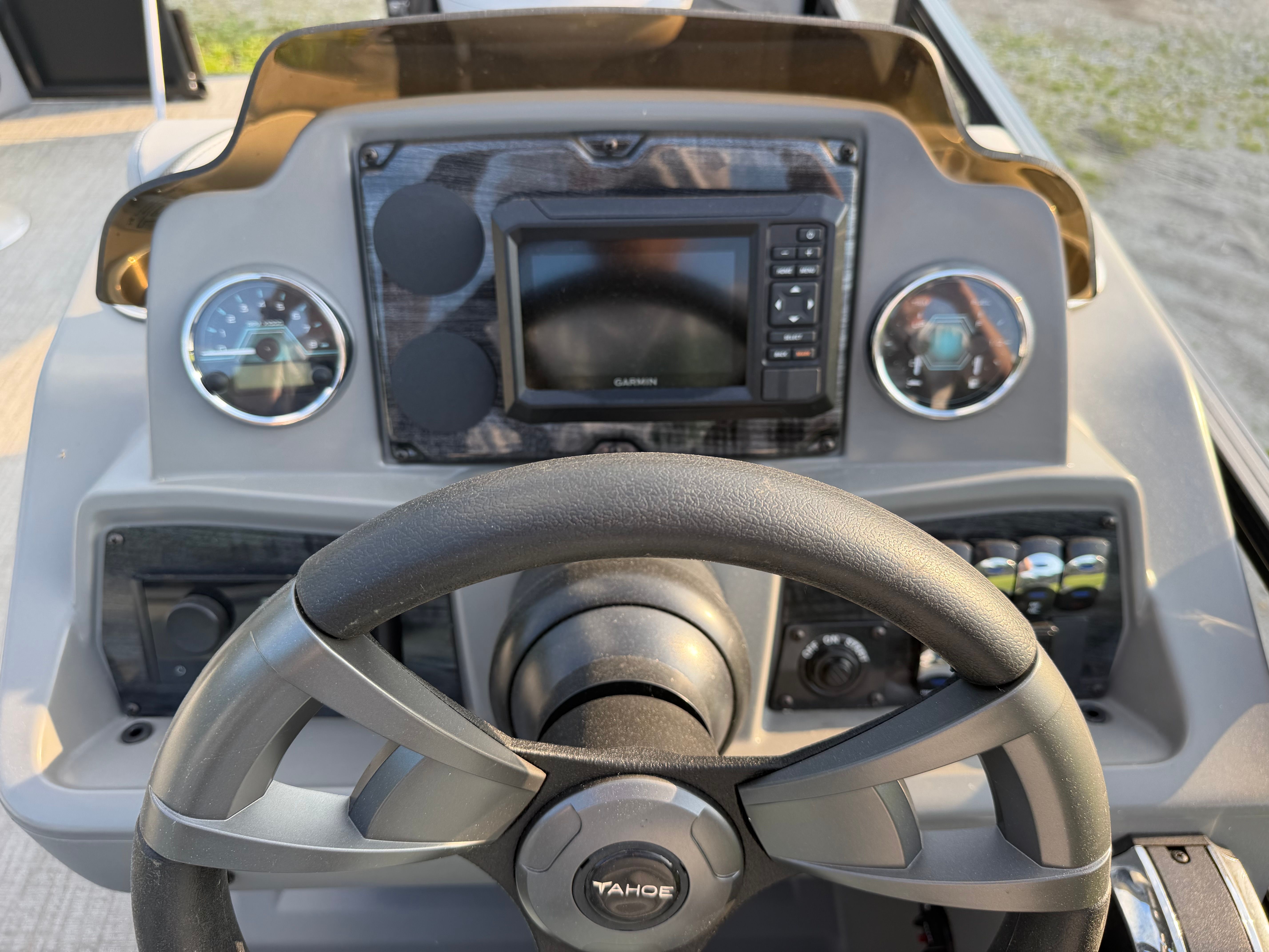 The image shows the helm of a Tahoe Pontoon 1980 Quad Fish with modern instruments.