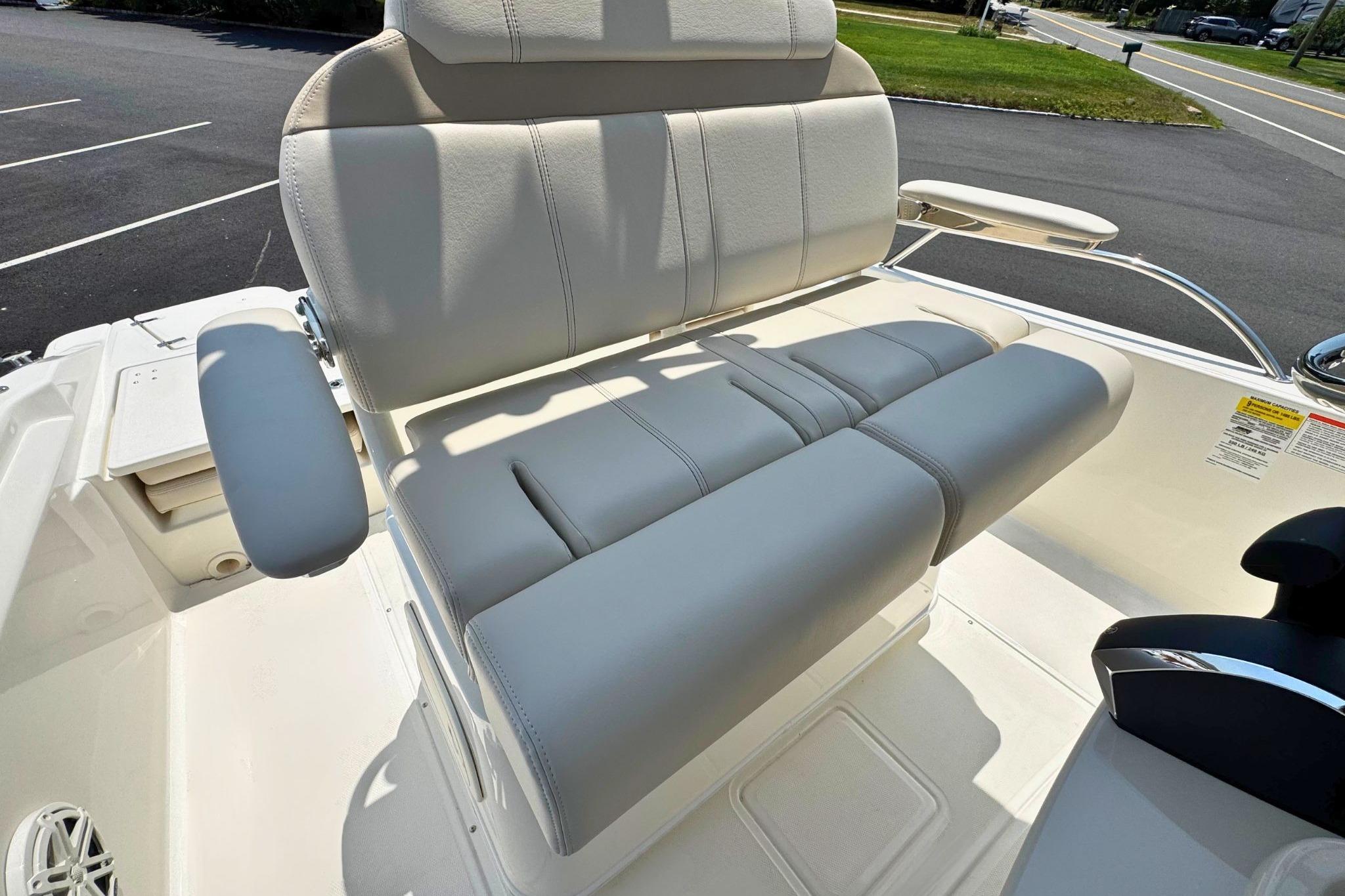 2026 Boston Whaler 220 Dauntless boat seat with cushioned armrests in a parking lot.