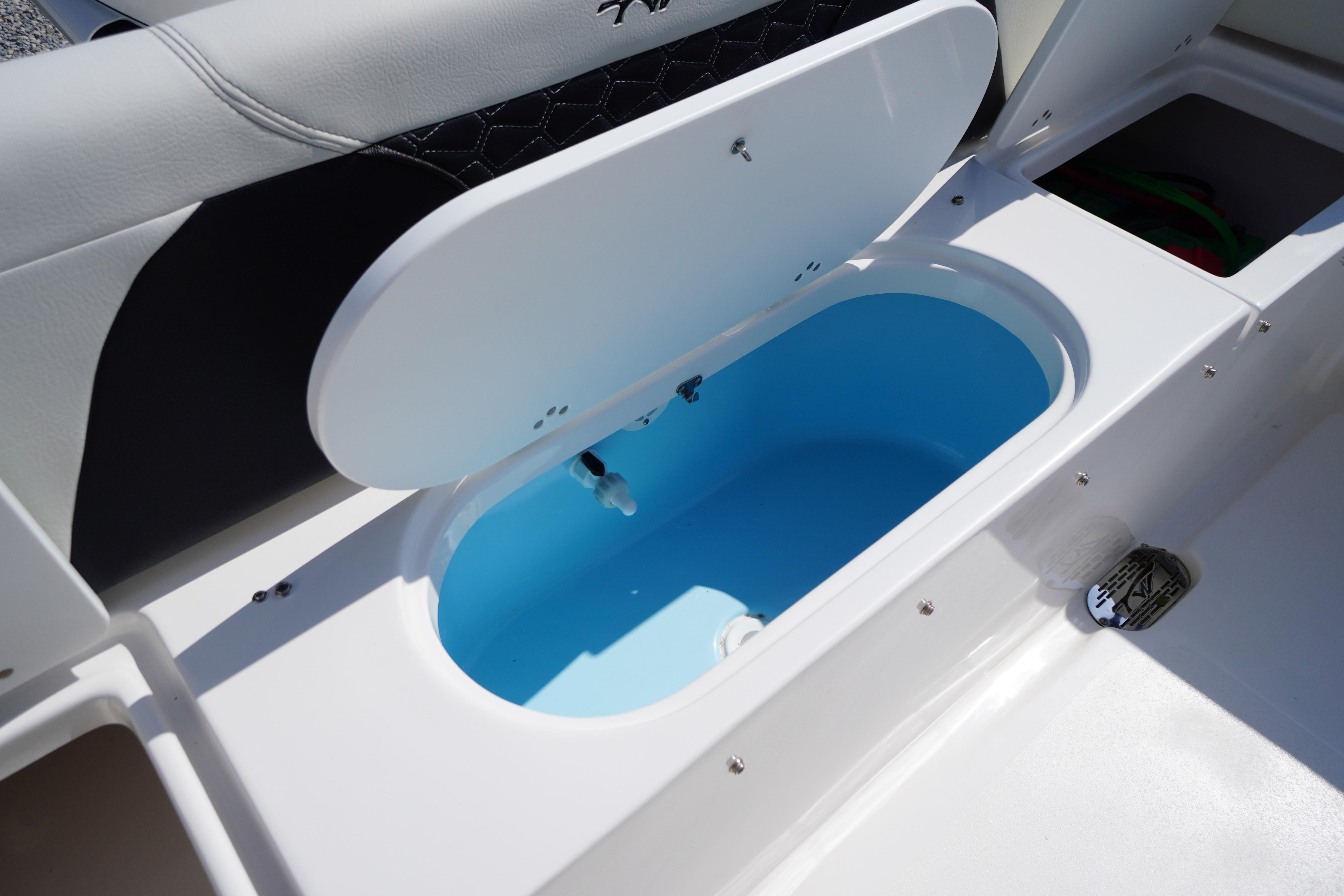 2025 Tidewater 232 SS boat interior with open storage compartment and seating.