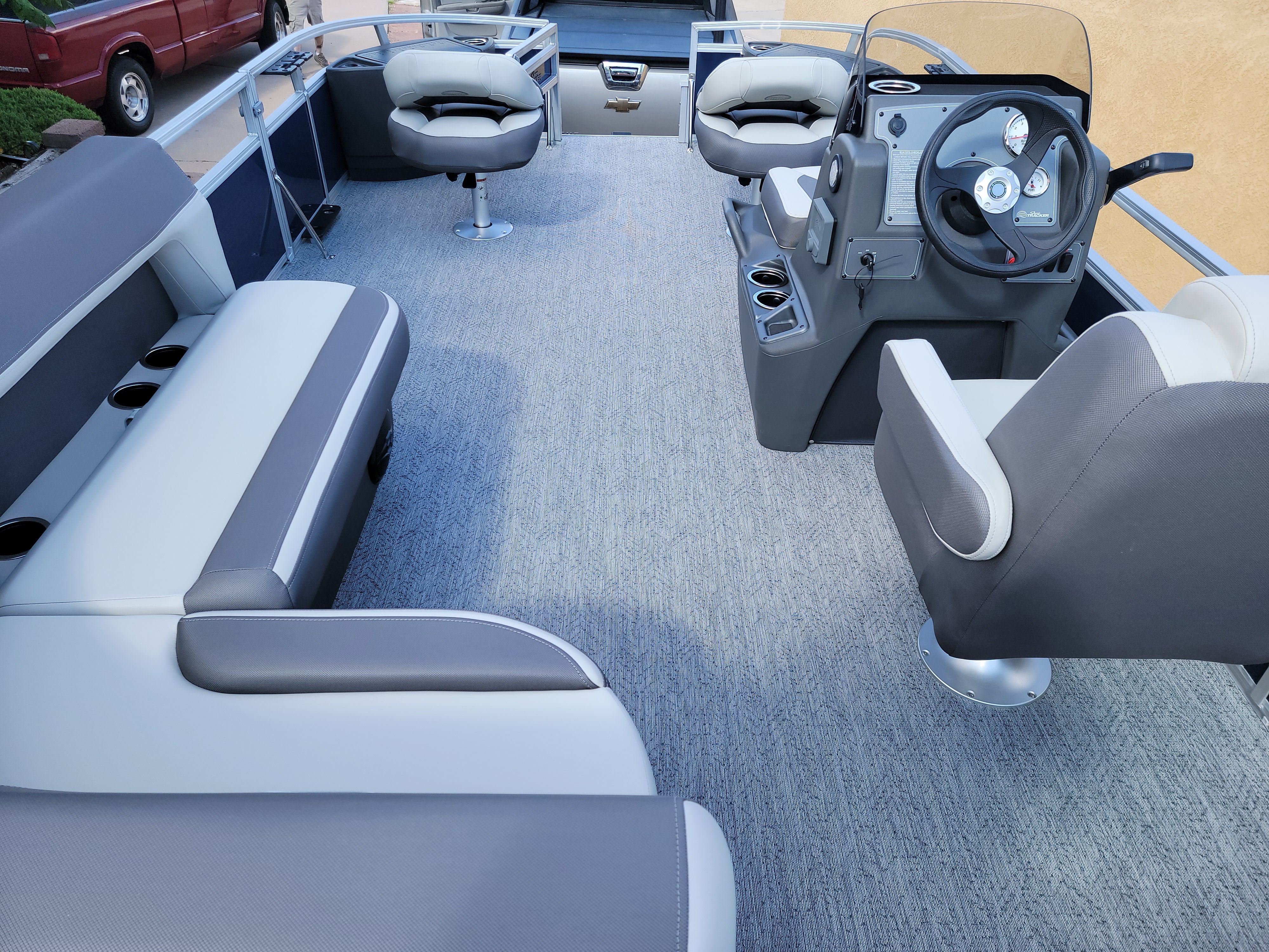 The image shows the interior of a Sun Tracker Bass Buggy 18 DLX boat with gray seating.
