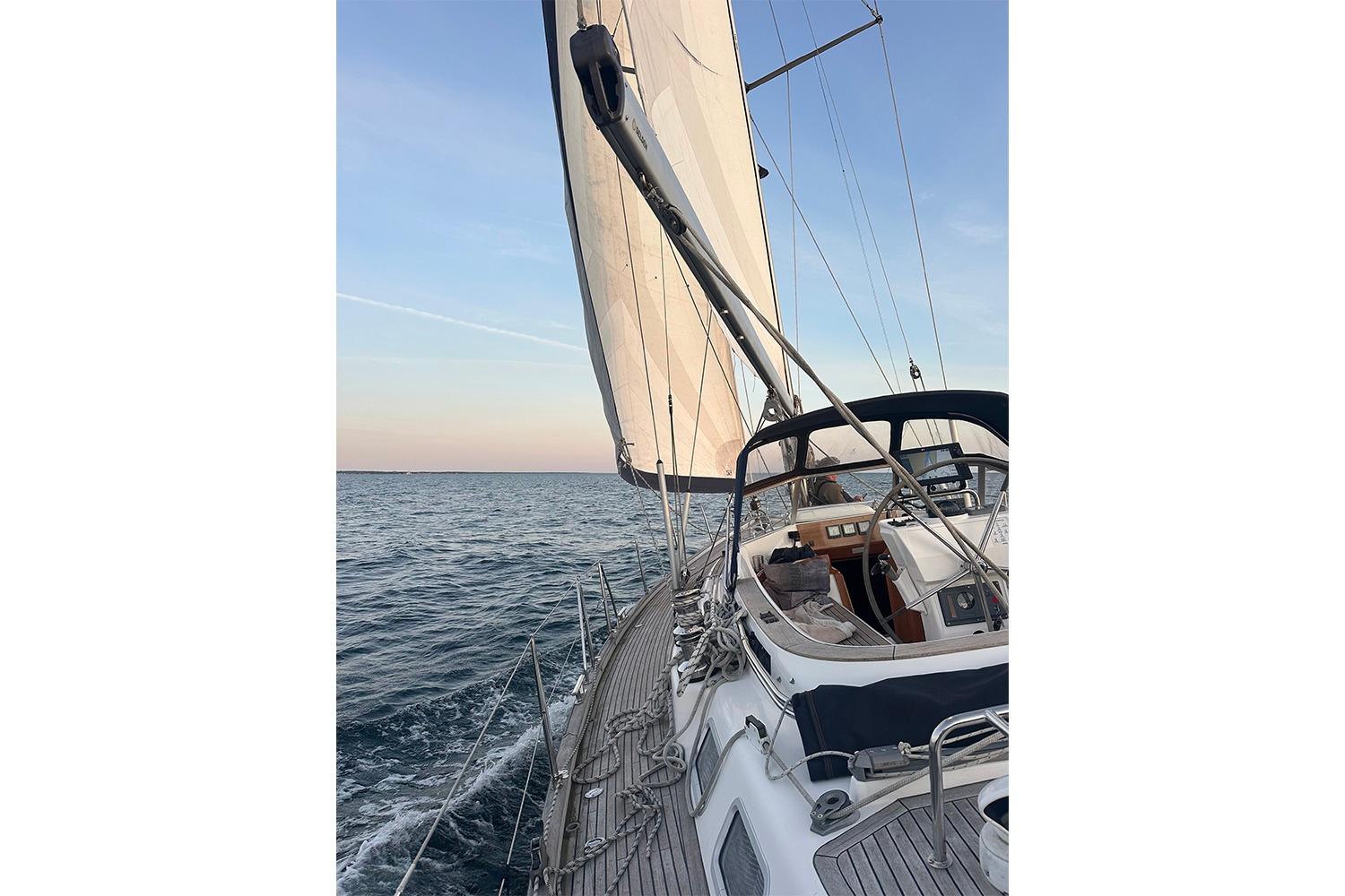 Sailing on a 2004 Najad 460 yacht with open sea and clear sky.