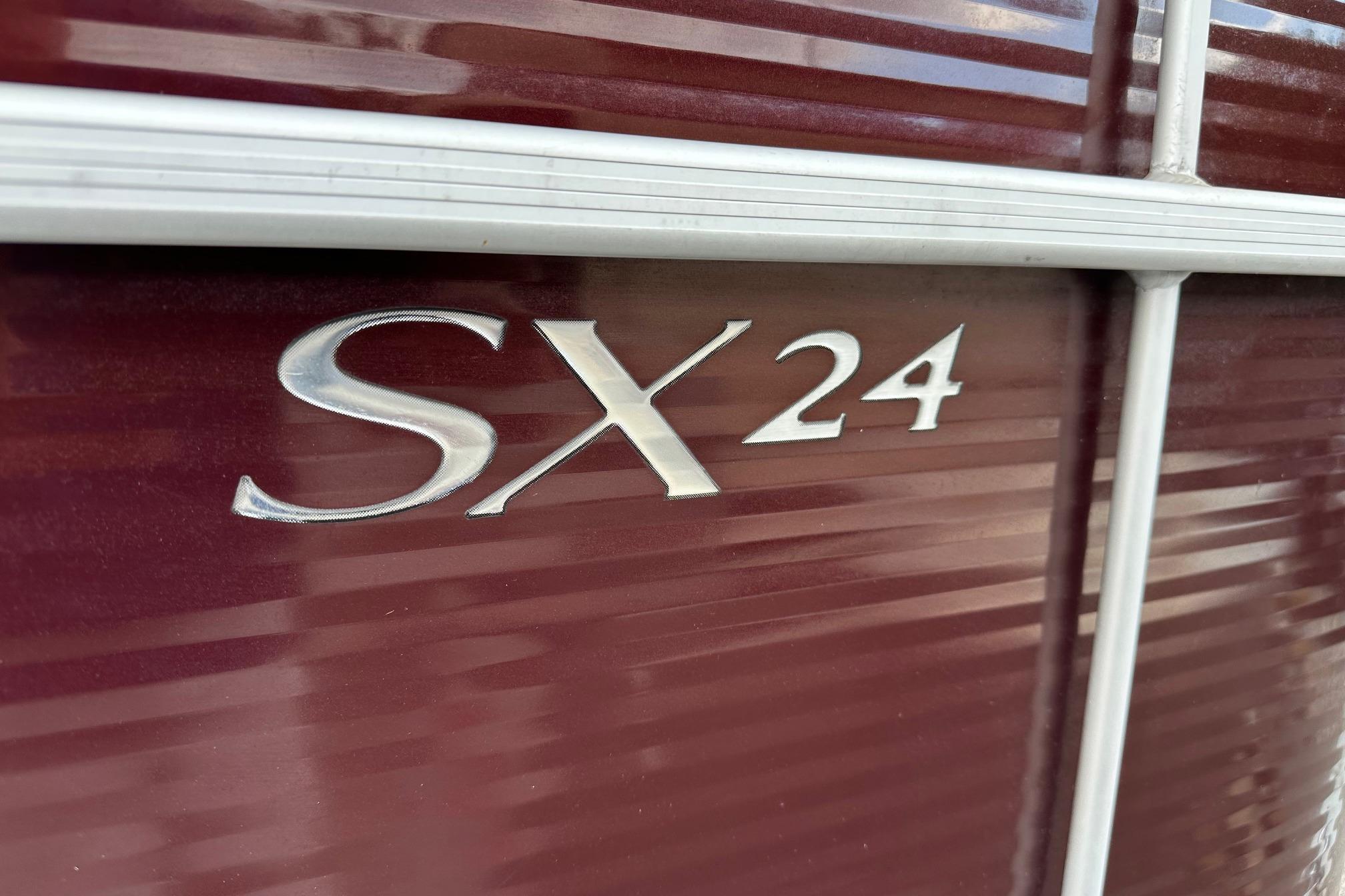 Close-up of 2016 Bennington 24 SCWX boat with "SX 24" emblem on maroon surface.