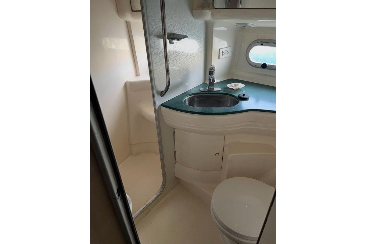 Bathroom interior of 1999 Sealine F44 yacht with sink, toilet, and shower.