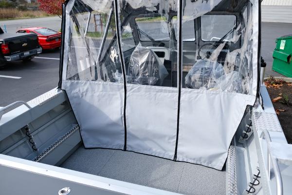 2024 Hewescraft 180 Pro-V ET boat with covered seating area in a parking lot.