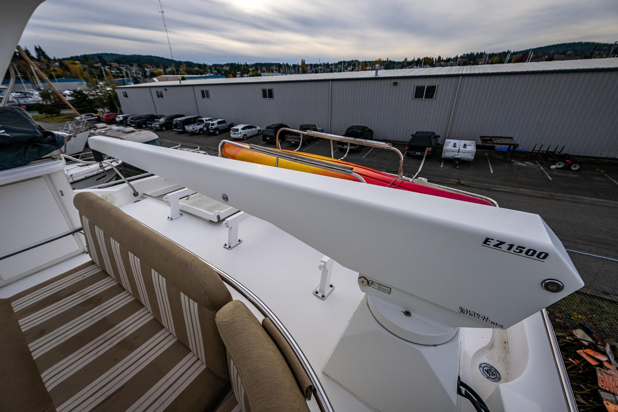 2001 Navigator Pilothouse yacht deck with EZ1500 crane and striped seating.