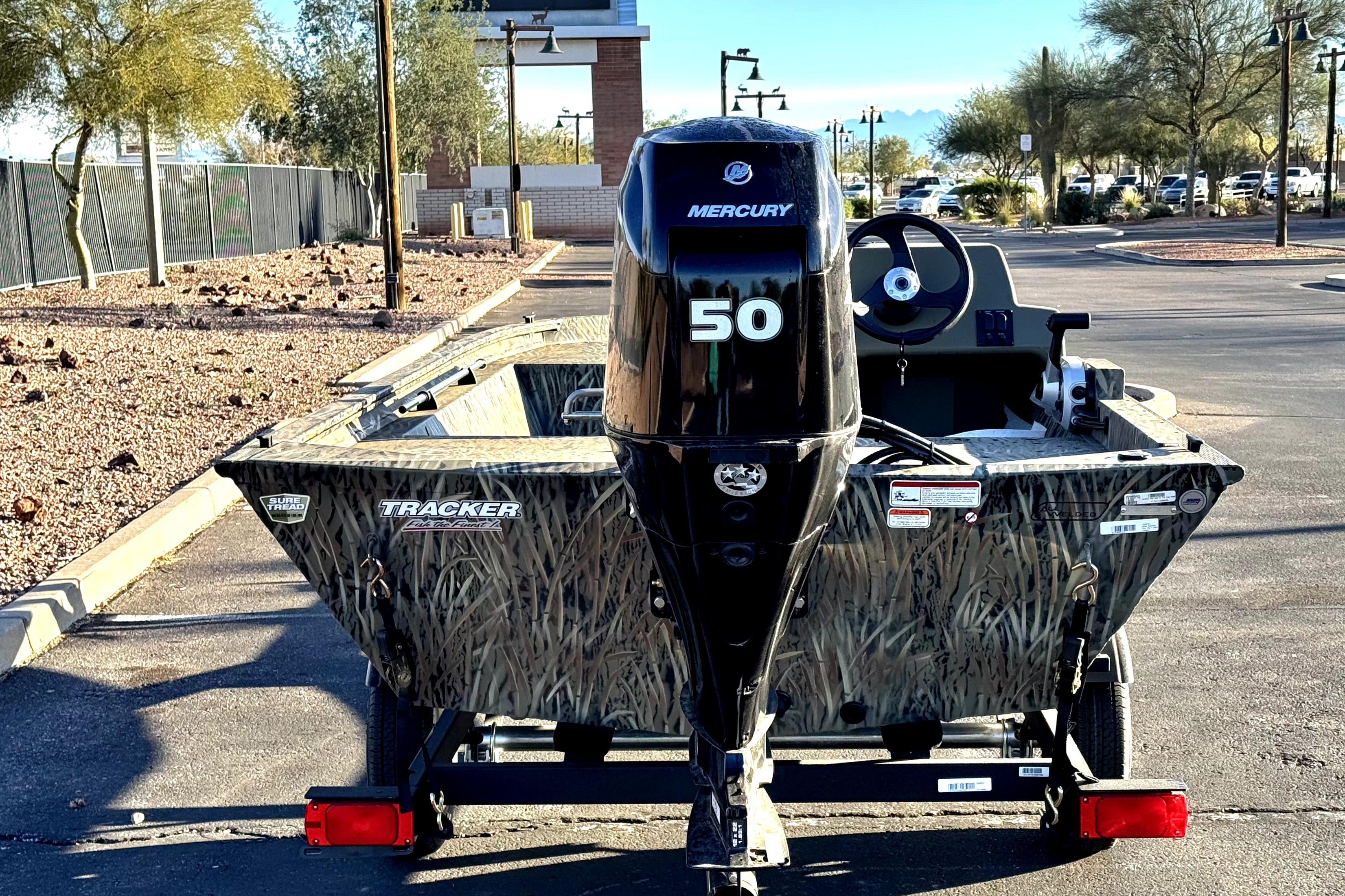 2026 Tracker Grizzly 1648 SC boat with Mercury 50 engine, parked outdoors.