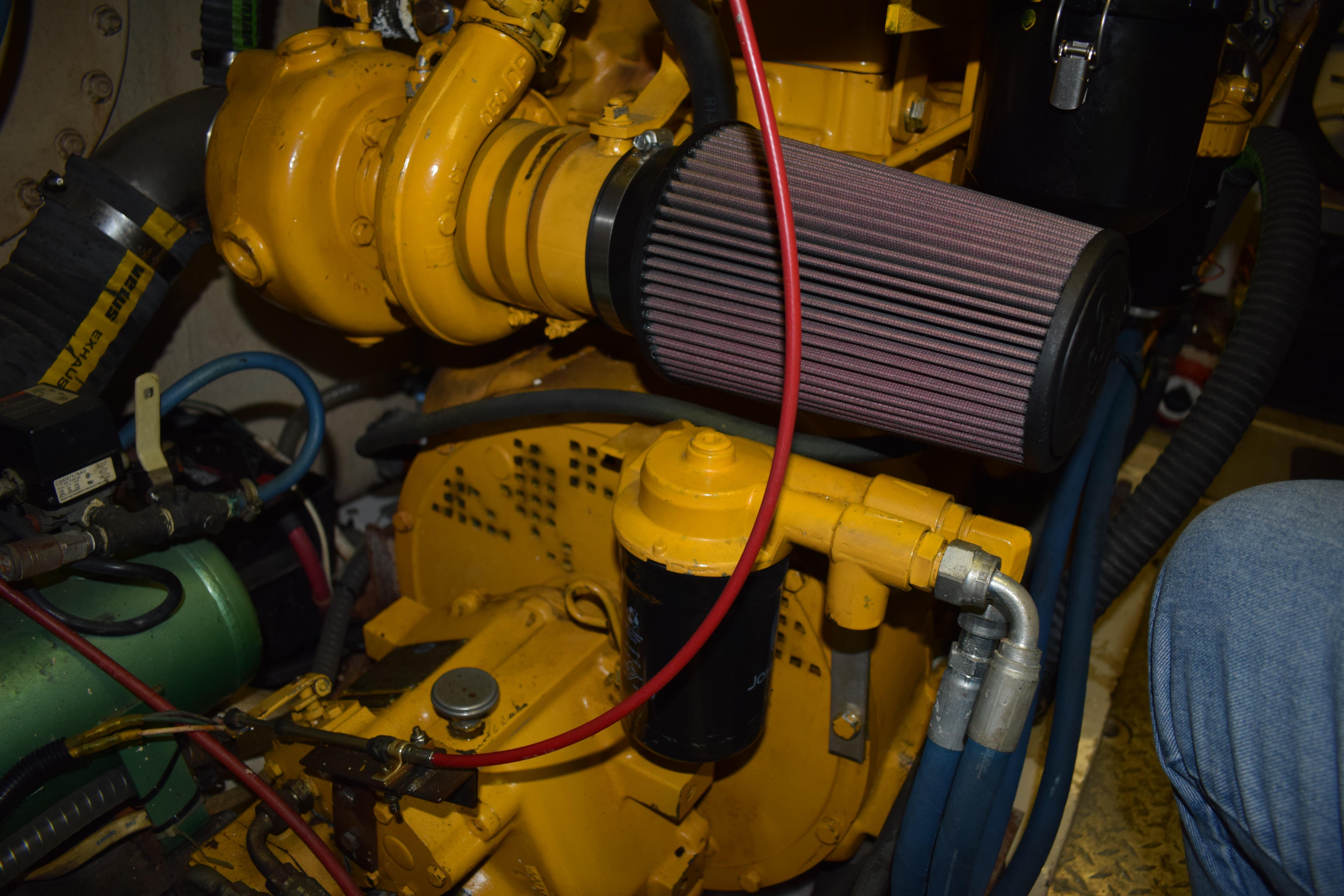 Engine compartment of a 1980 Cheoy Lee 52 Motorsailer, featuring yellow machinery and hoses.