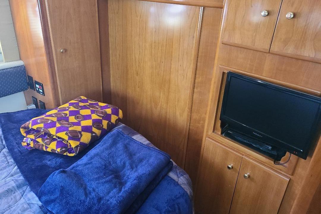 Interior of 2003 Carver 356 Aft Cabin Motor Yacht with TV and folded blankets.