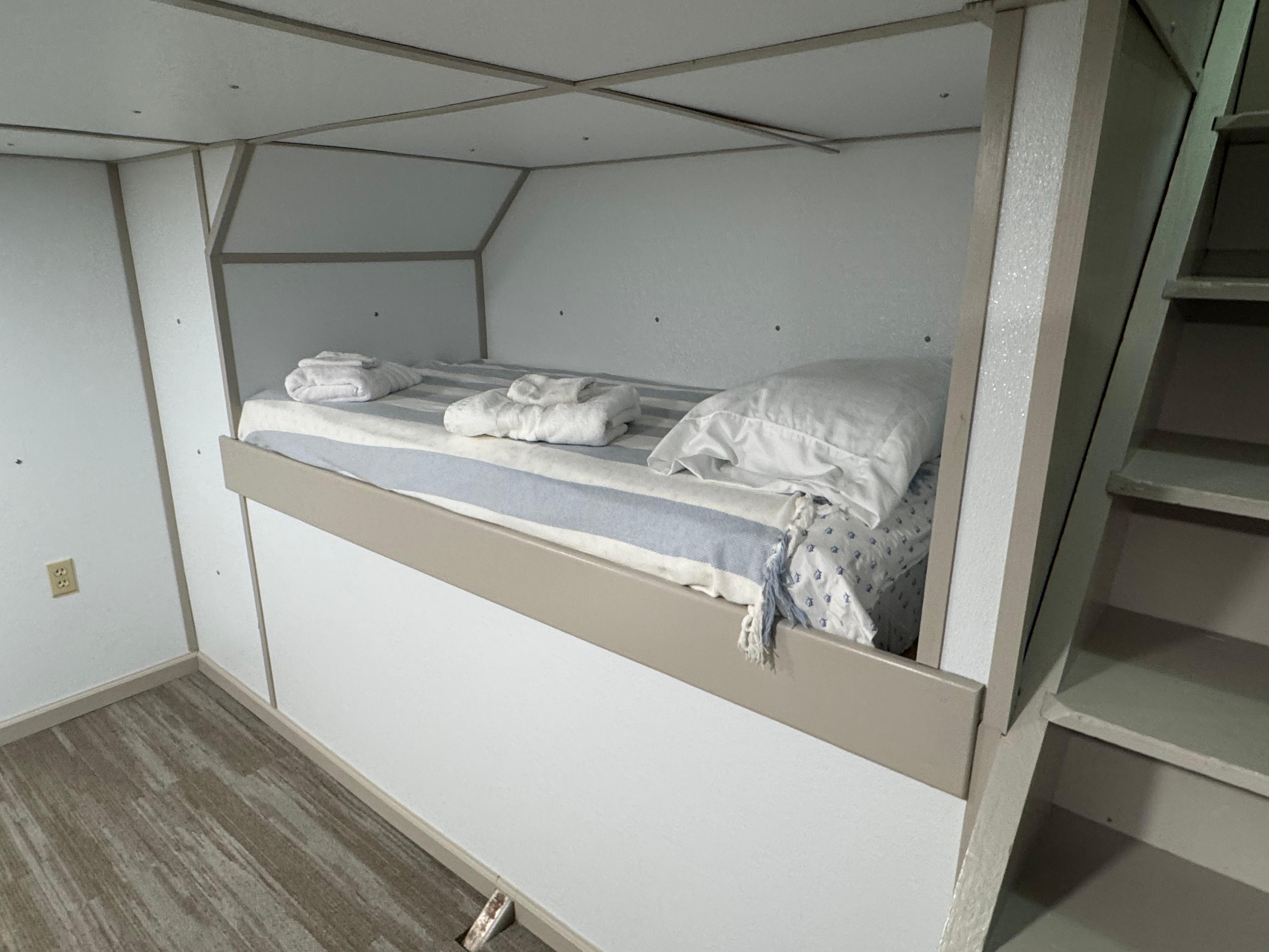 Compact bunk bed in a 1985 custom houseboat interior with minimalist design.