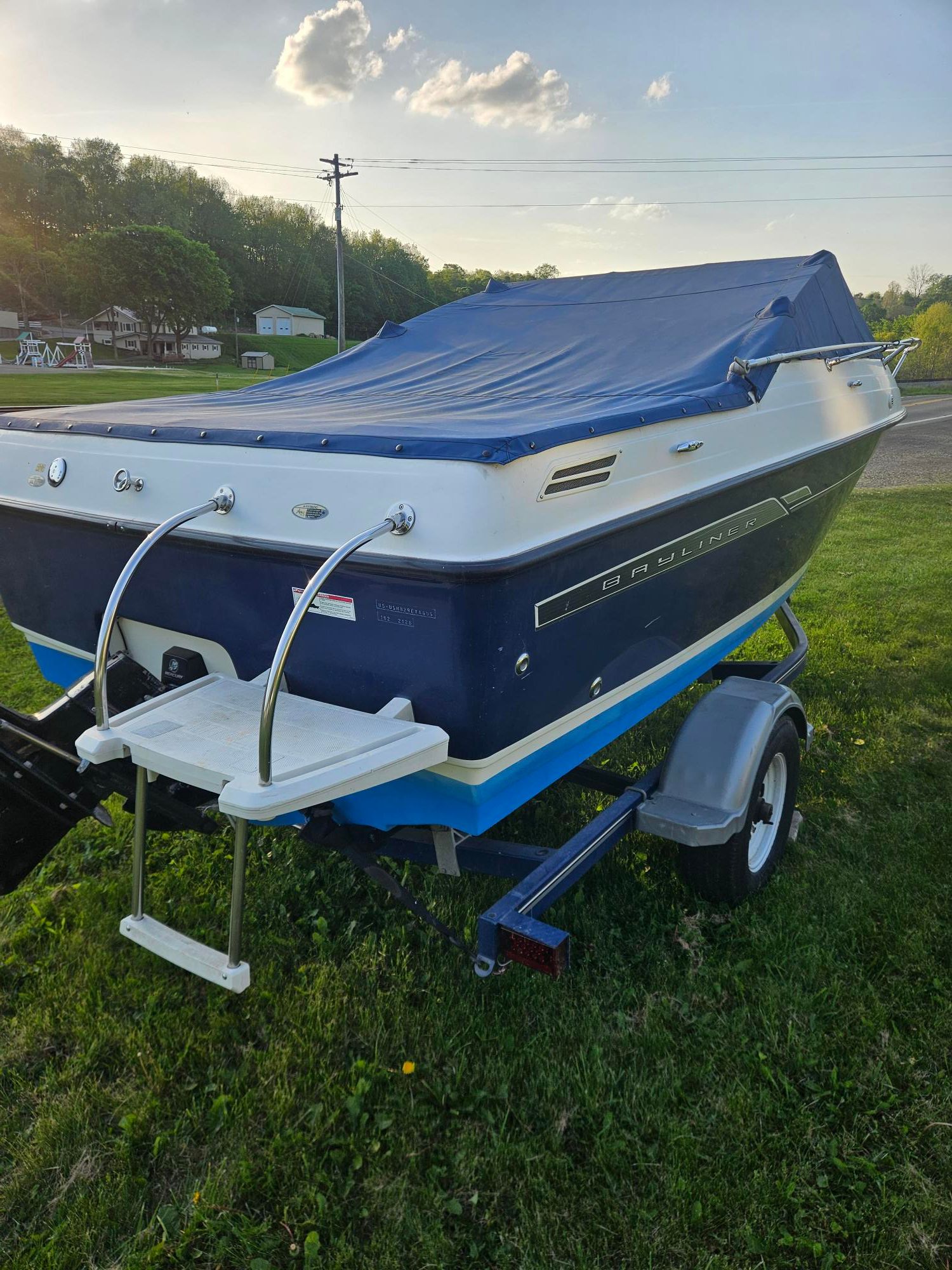 2006 Bayliner Cuddy Cab on trailer, blue cover.