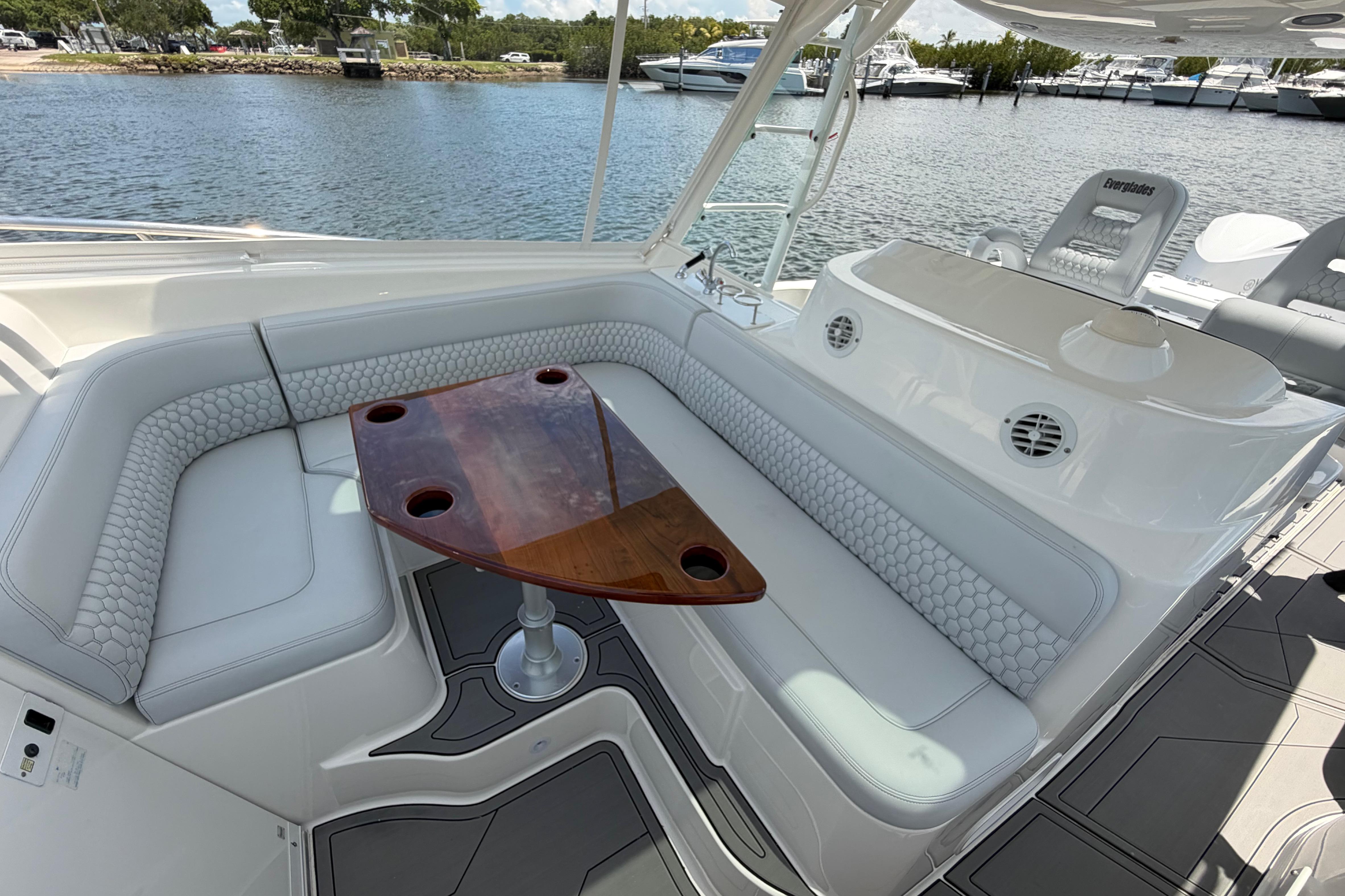 Luxurious seating area on a 2009 Everglades 350LX boat with a wooden table.